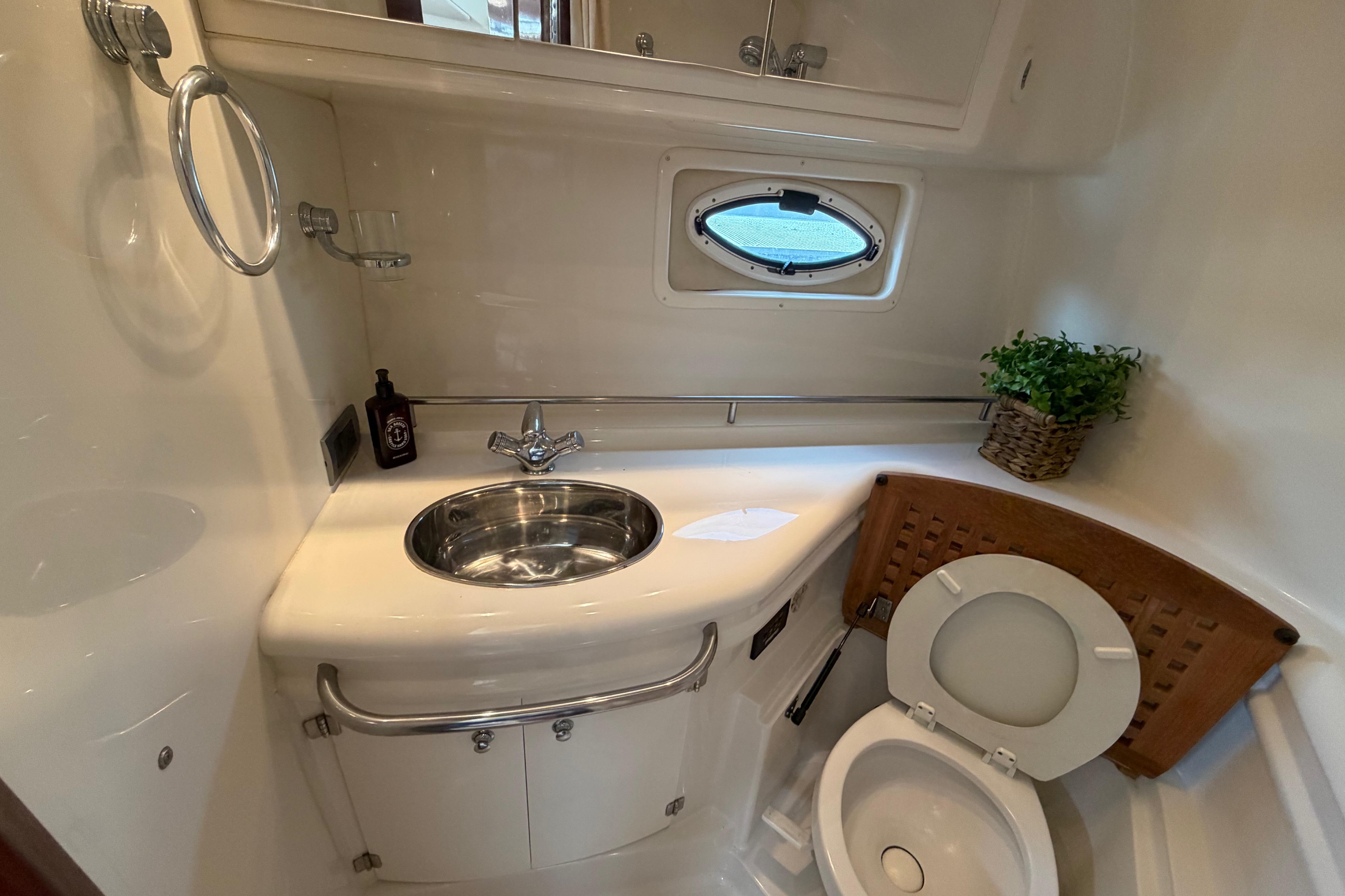 2007 Monterey 350 Sport Yacht bathroom with sink, toilet, and porthole window.