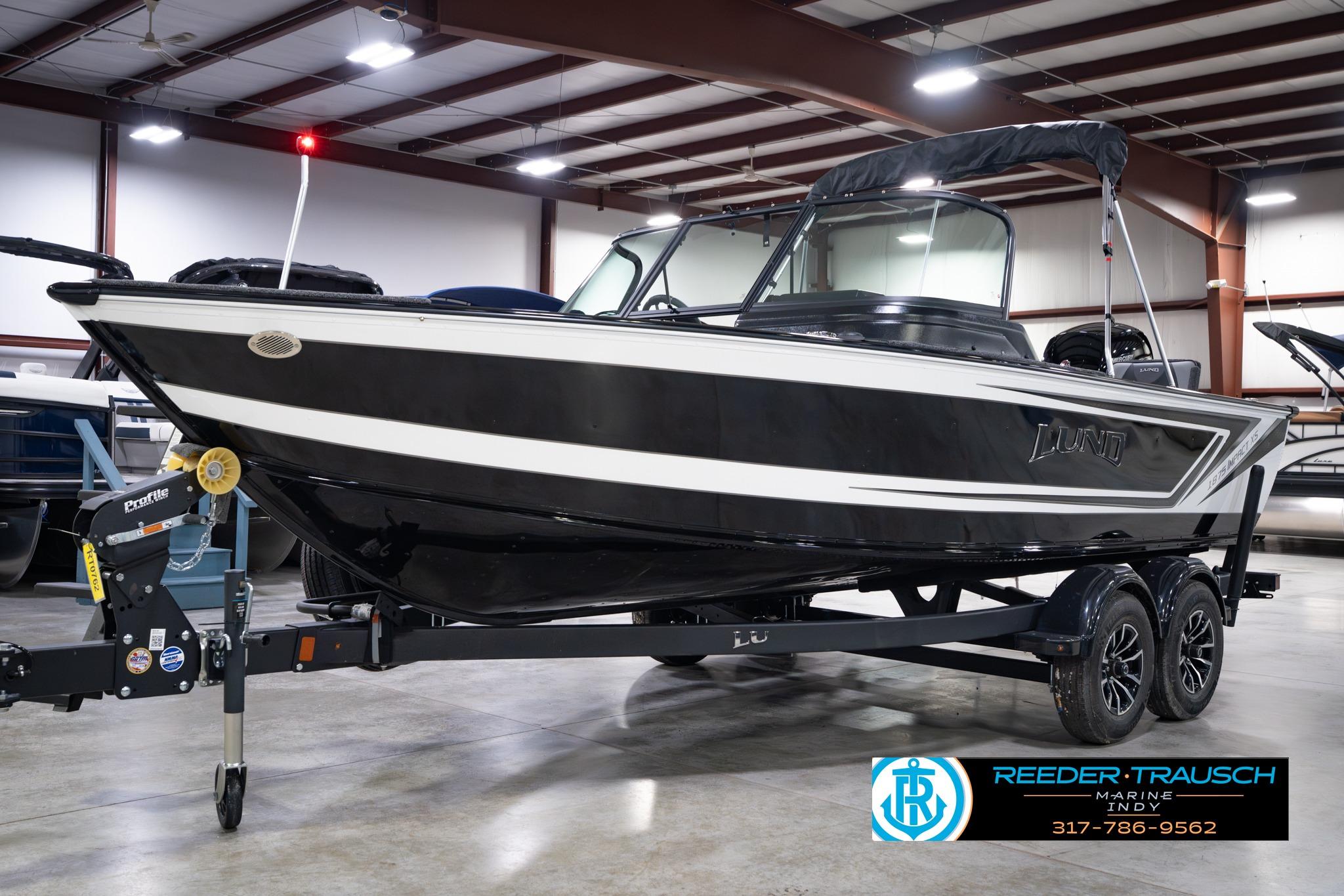 2026 Lund 1875 Impact XS SS boat in showroom, black and white design on trailer.