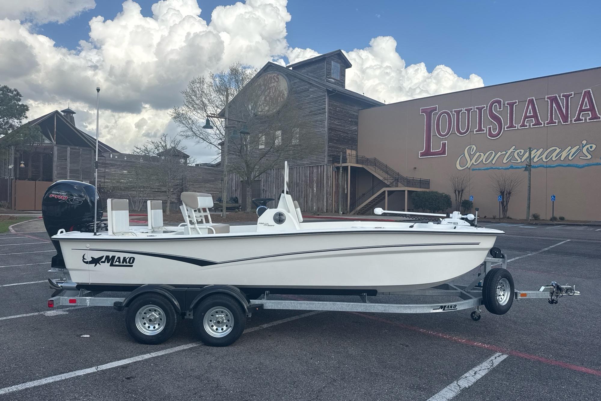 2026 Mako Pro Skiff 19 CC boat on trailer in parking lot, Louisiana Sportsman's backdrop.
