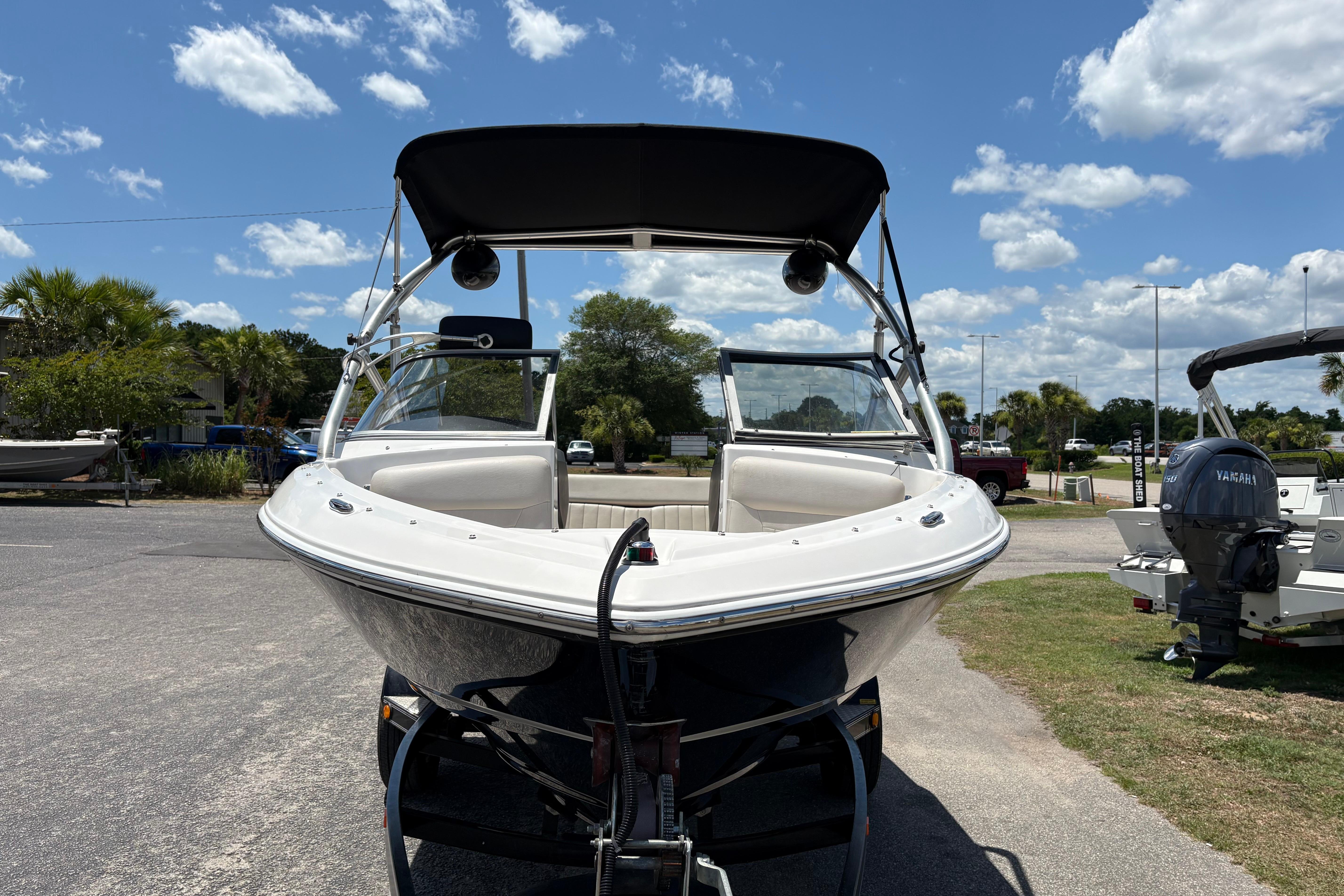 2008 Regal 1900 Bowrider boat on trailer under sunny sky.