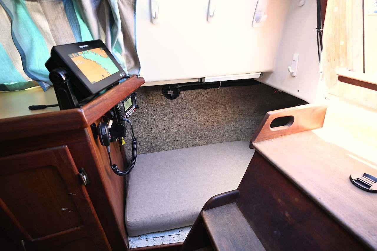 Interior of 1977 Mercator Offshore boat with navigation equipment and cozy sleeping area.