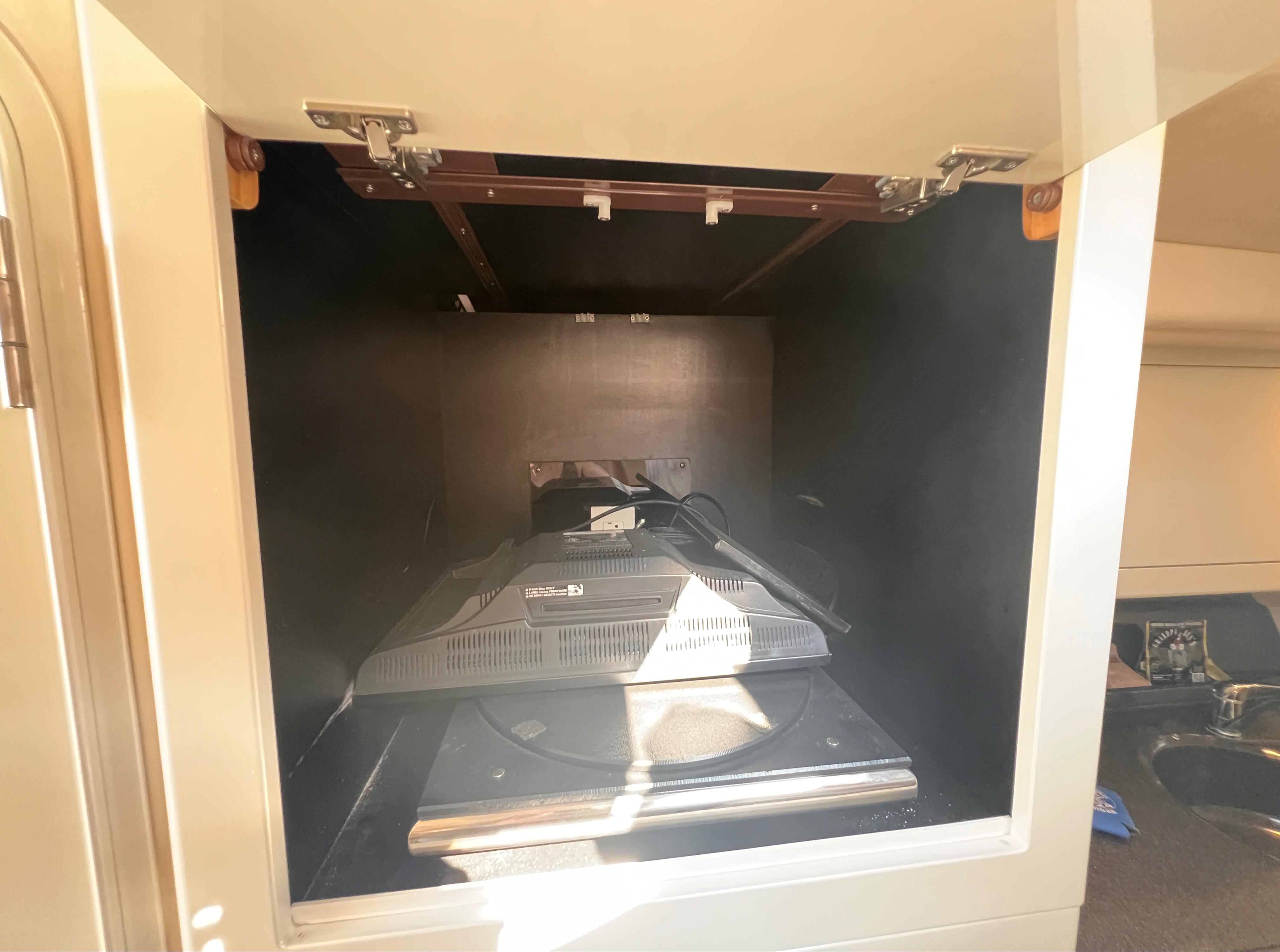 Storage compartment inside 2000 Wellcraft 45 Excalibur boat, featuring a mounted TV.