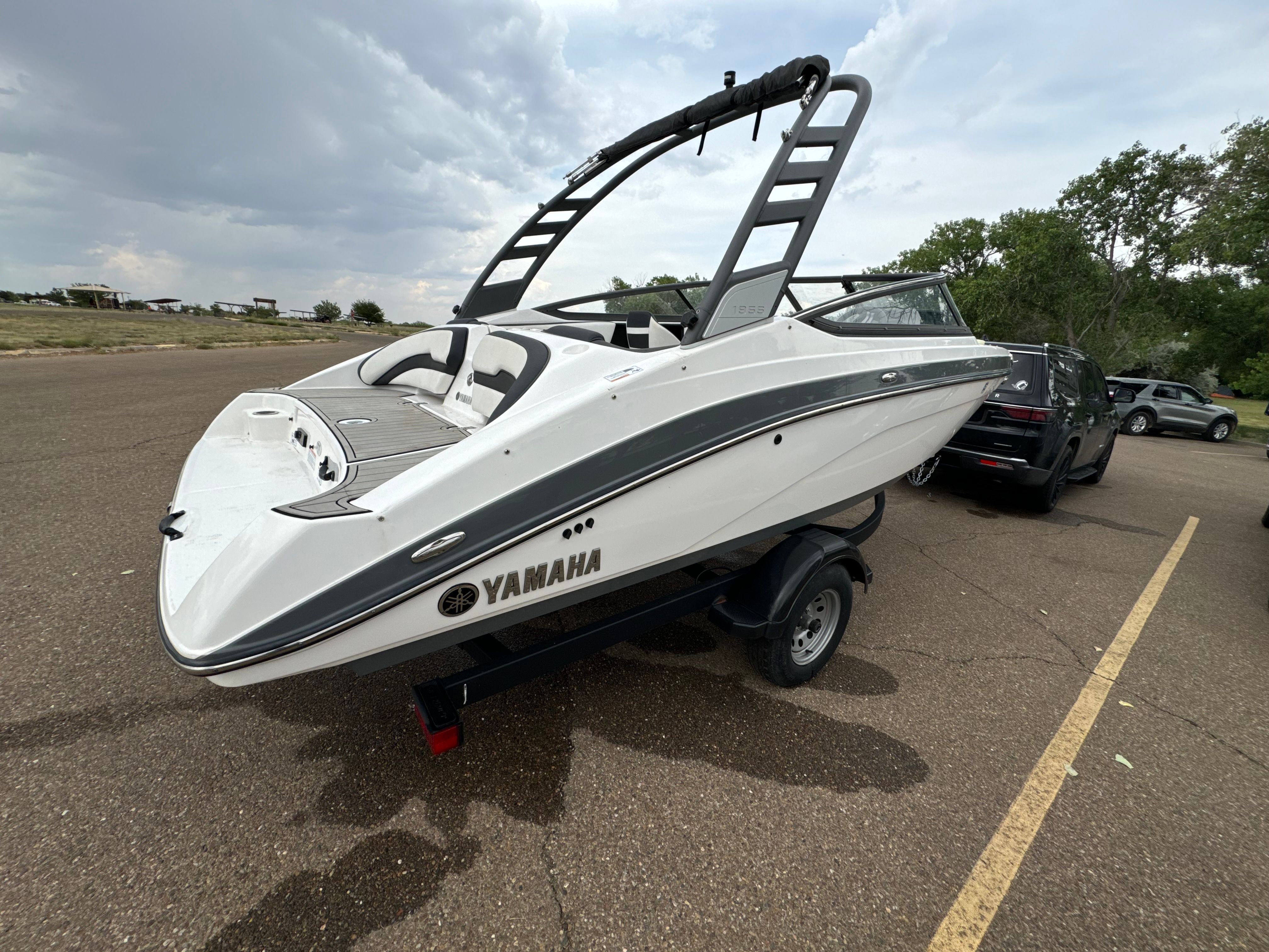 A white Yamaha 195S boat from 2020 is on a trailer in a parking lot.