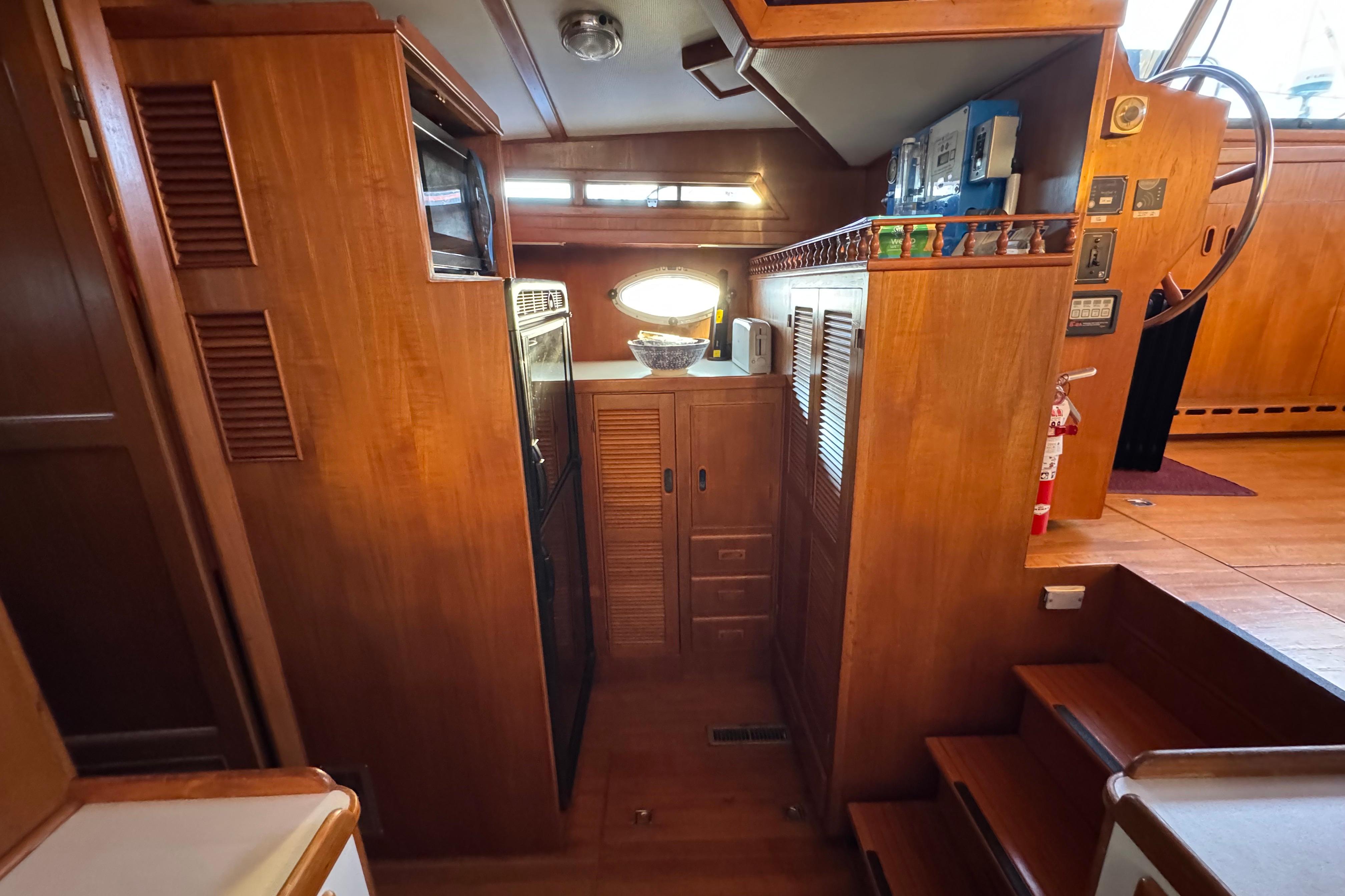 Interior of a 1987 President 37 yacht with wooden cabinetry and nautical decor.
