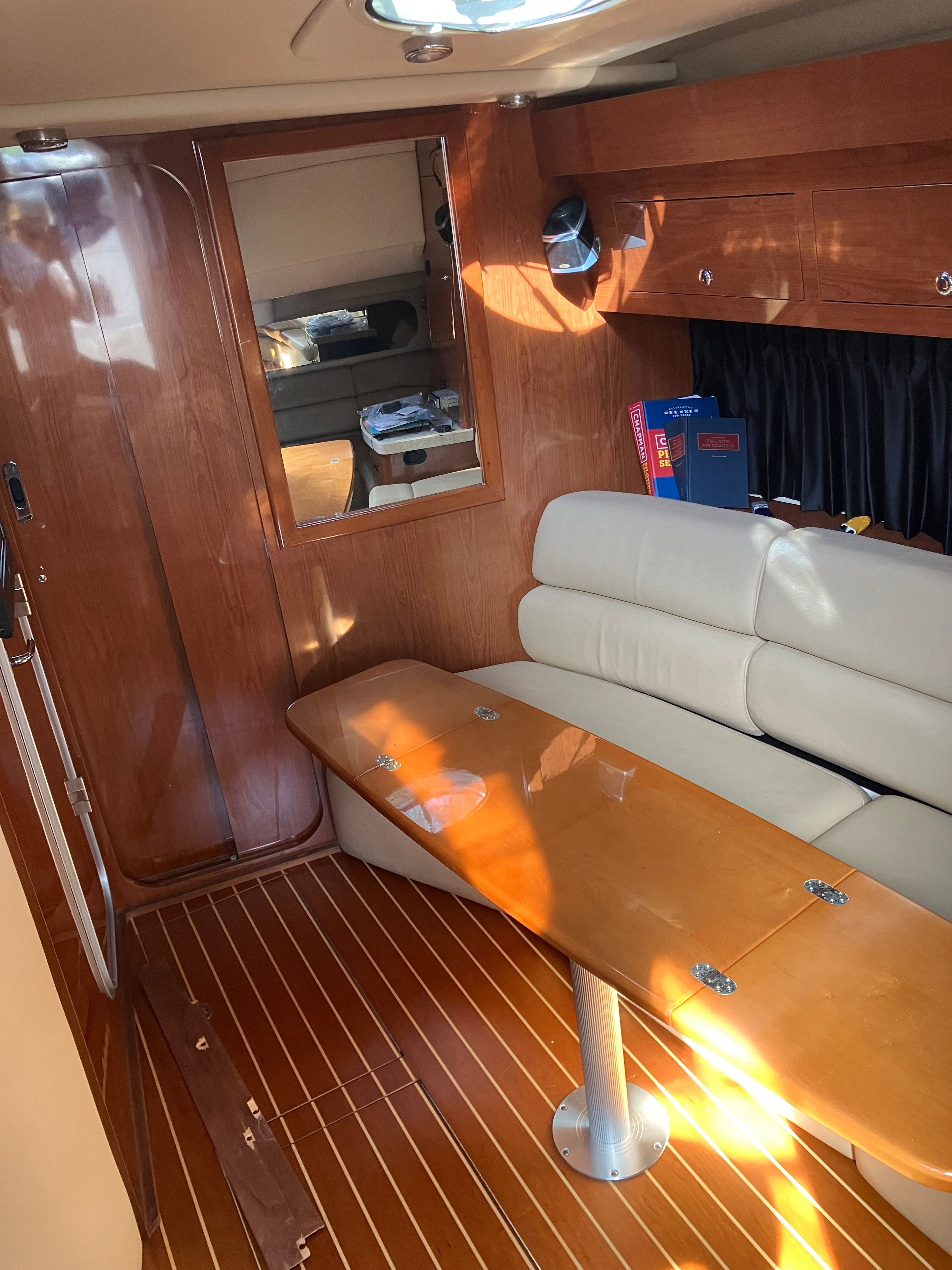 Interior of a 2008 Custom Commodore yacht with wooden table and leather seating.