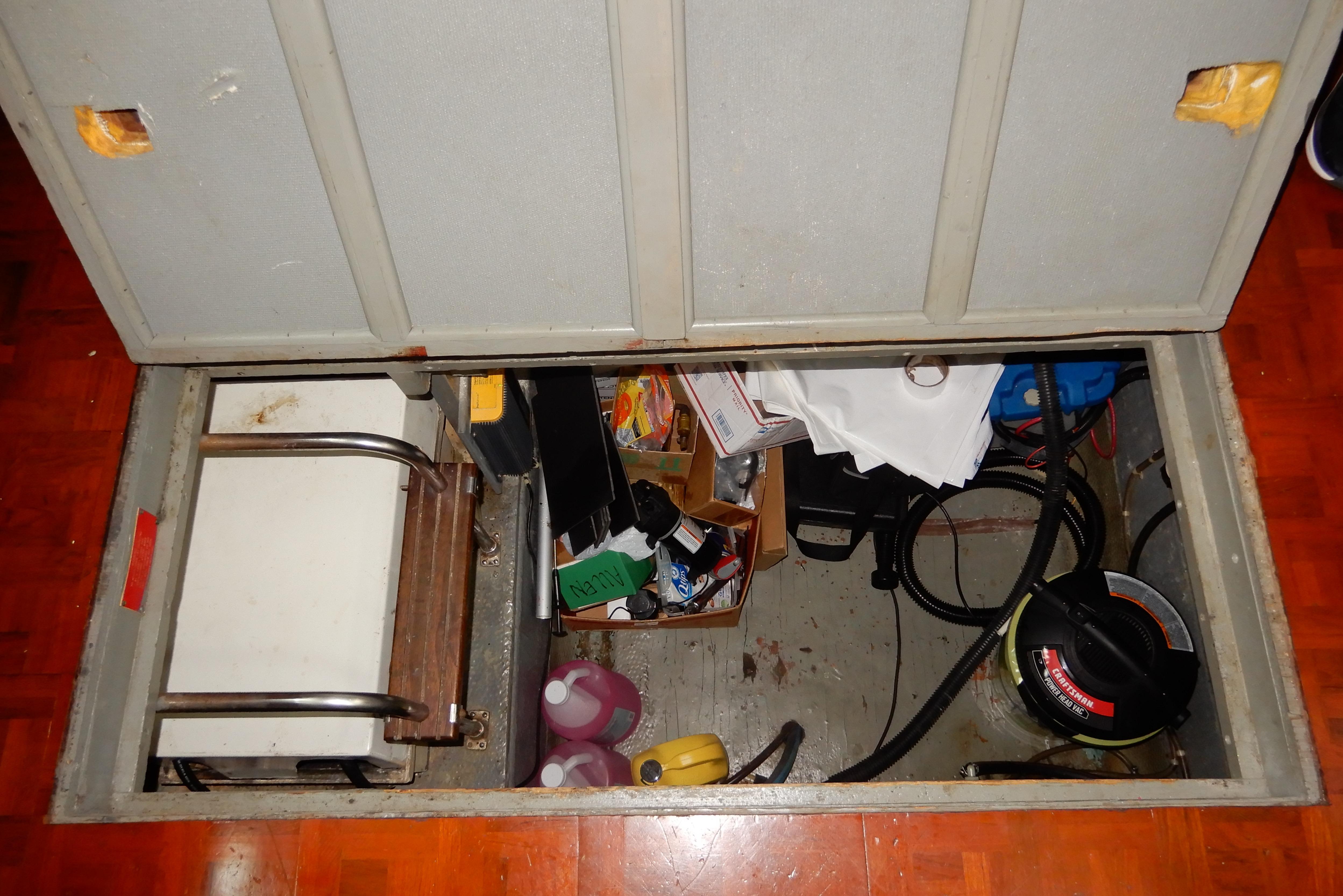 Storage compartment on a 1979 Hatteras 53 Motor Yacht with various tools and supplies.