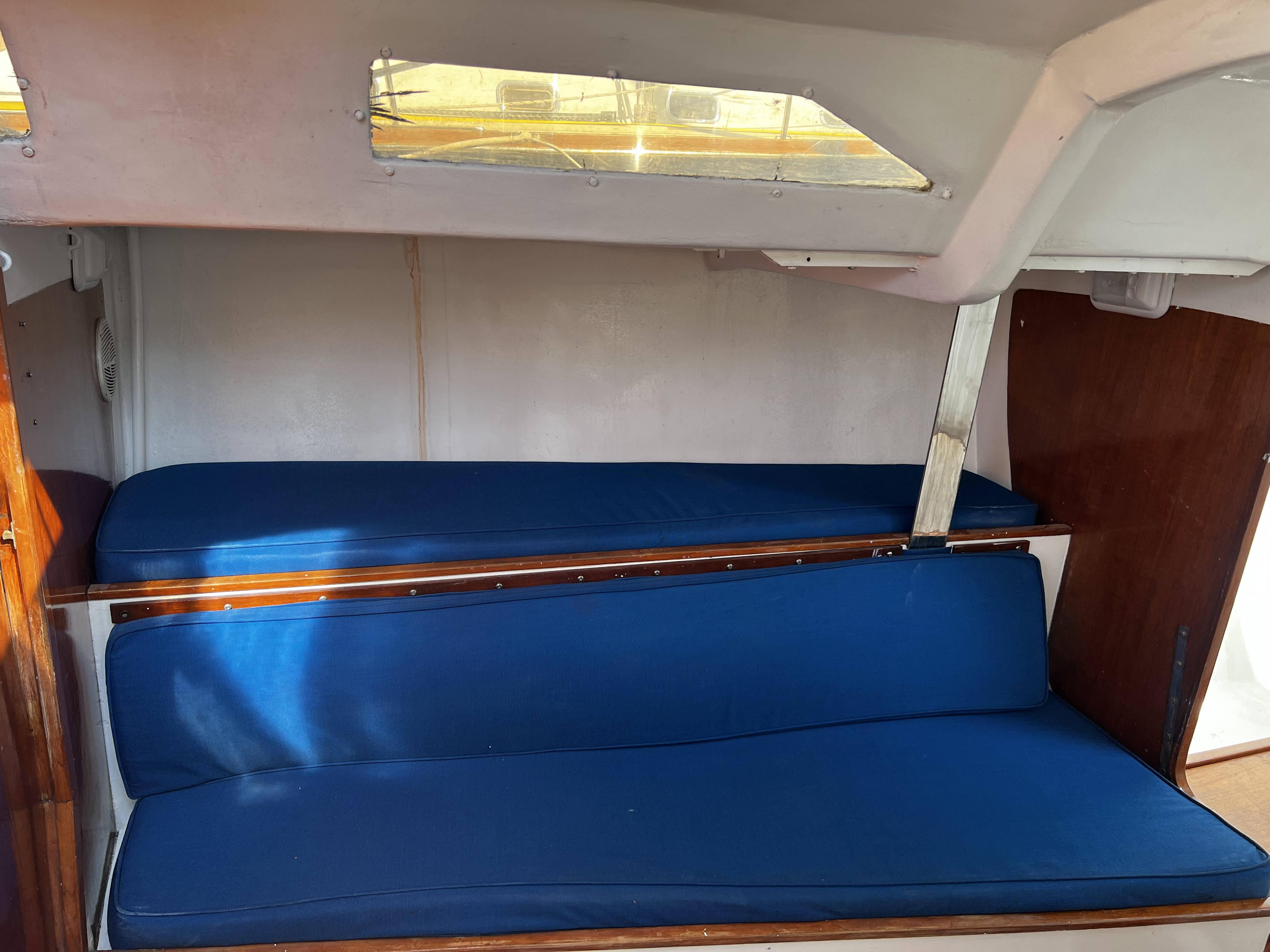 Interior of 1989 Taylor 40 sailboat with blue cushioned seating.