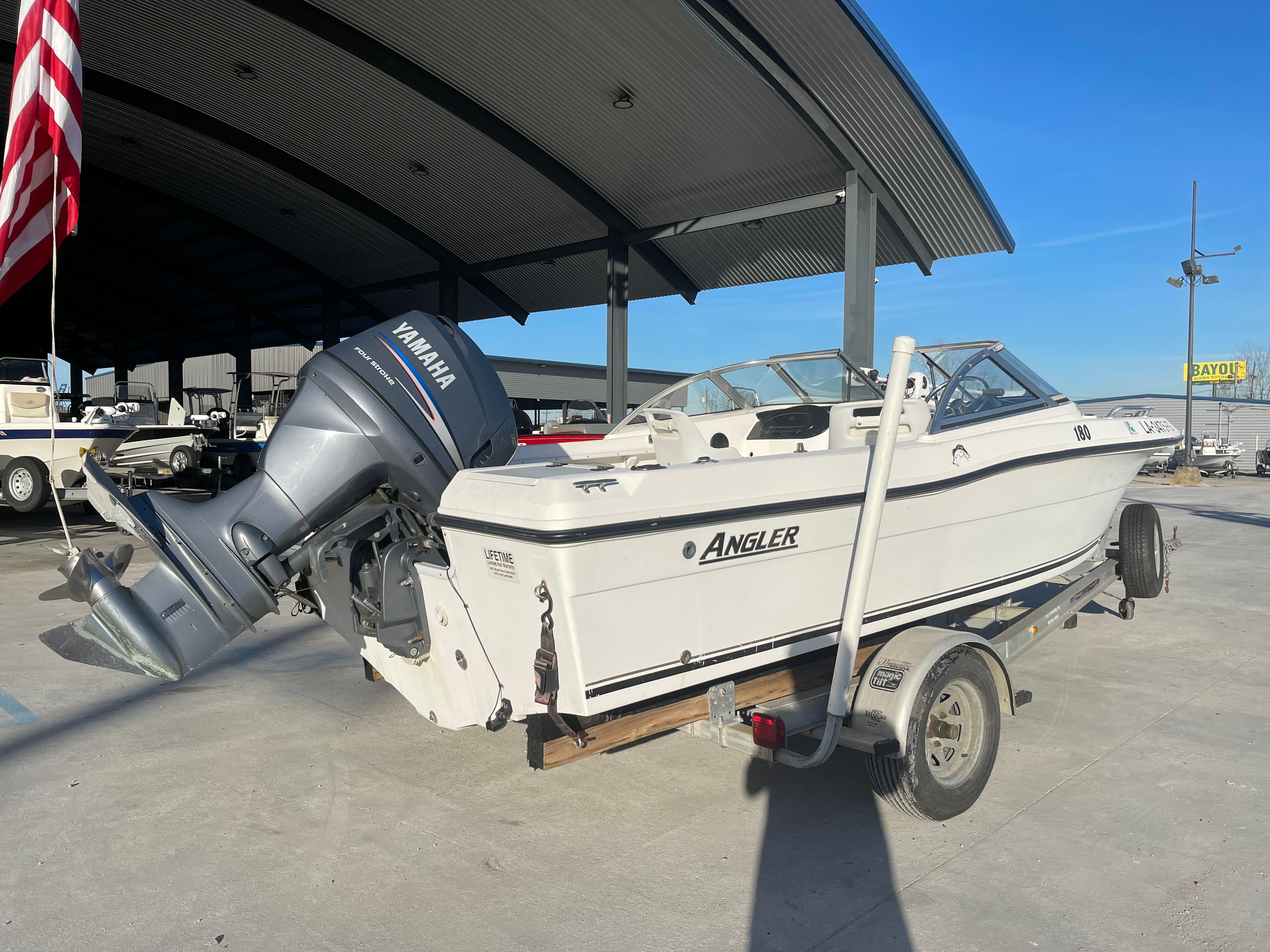 2002 Angler 18 DC boat with Yamaha outboard motor on trailer, parked outdoors.