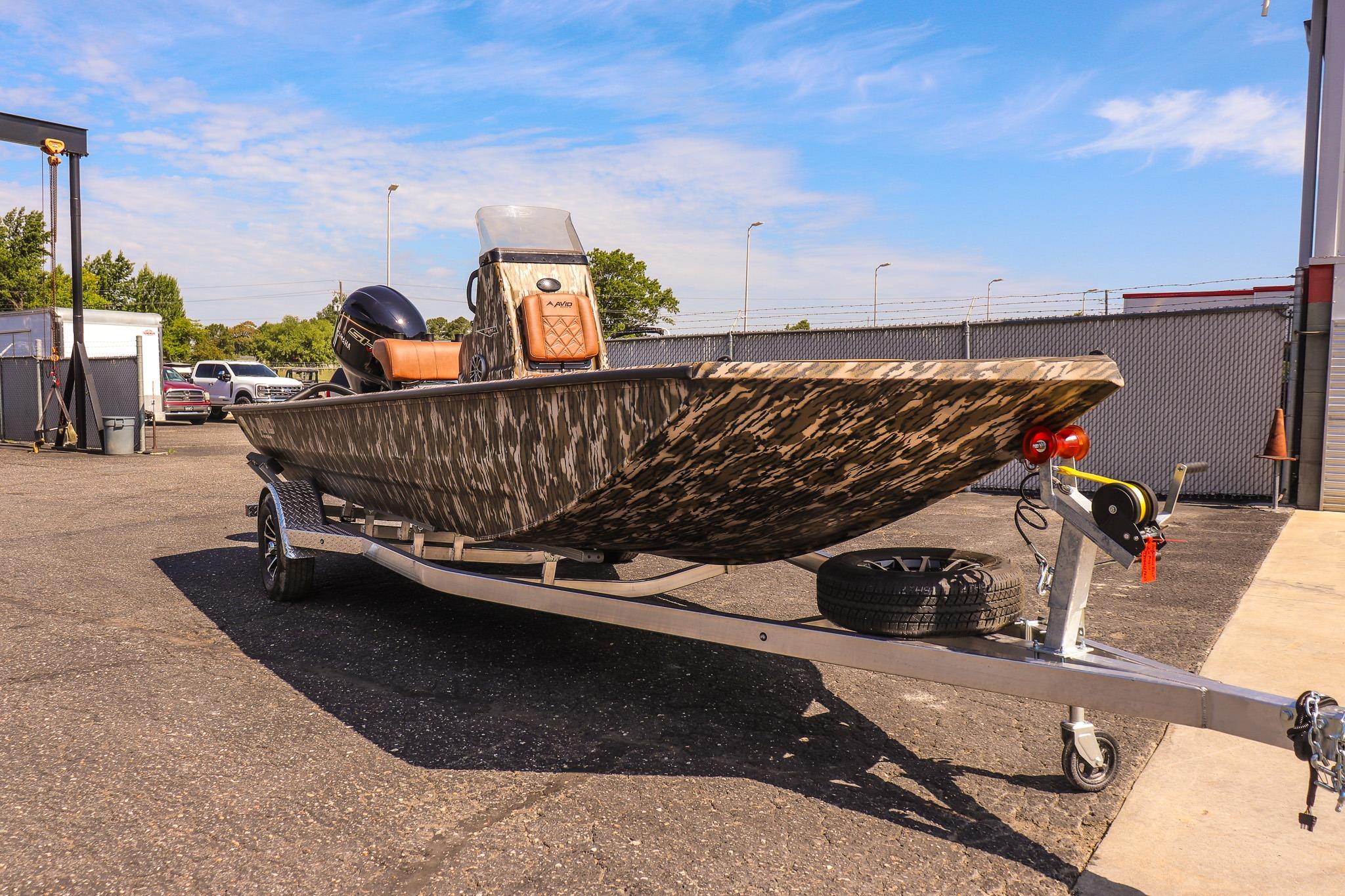 Avid 20 Rogue CC 2027 on a trailer, featuring a camouflaged hull and an outboard motor.