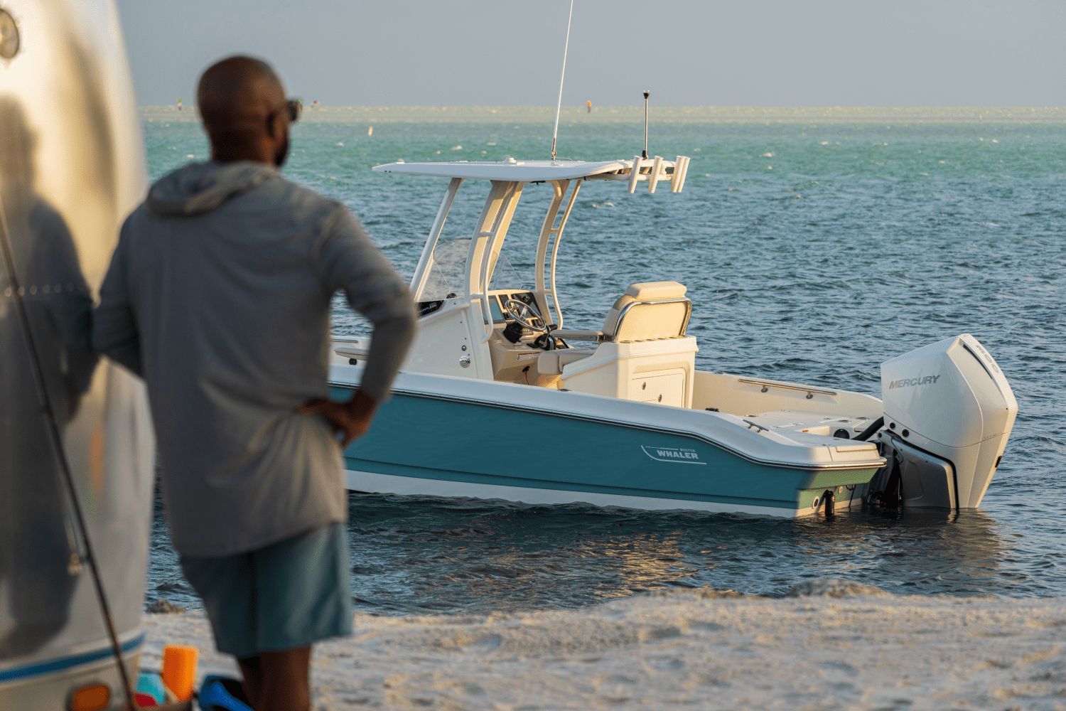 A 2027 Boston Whaler 25DA is in calm waters near a beach.