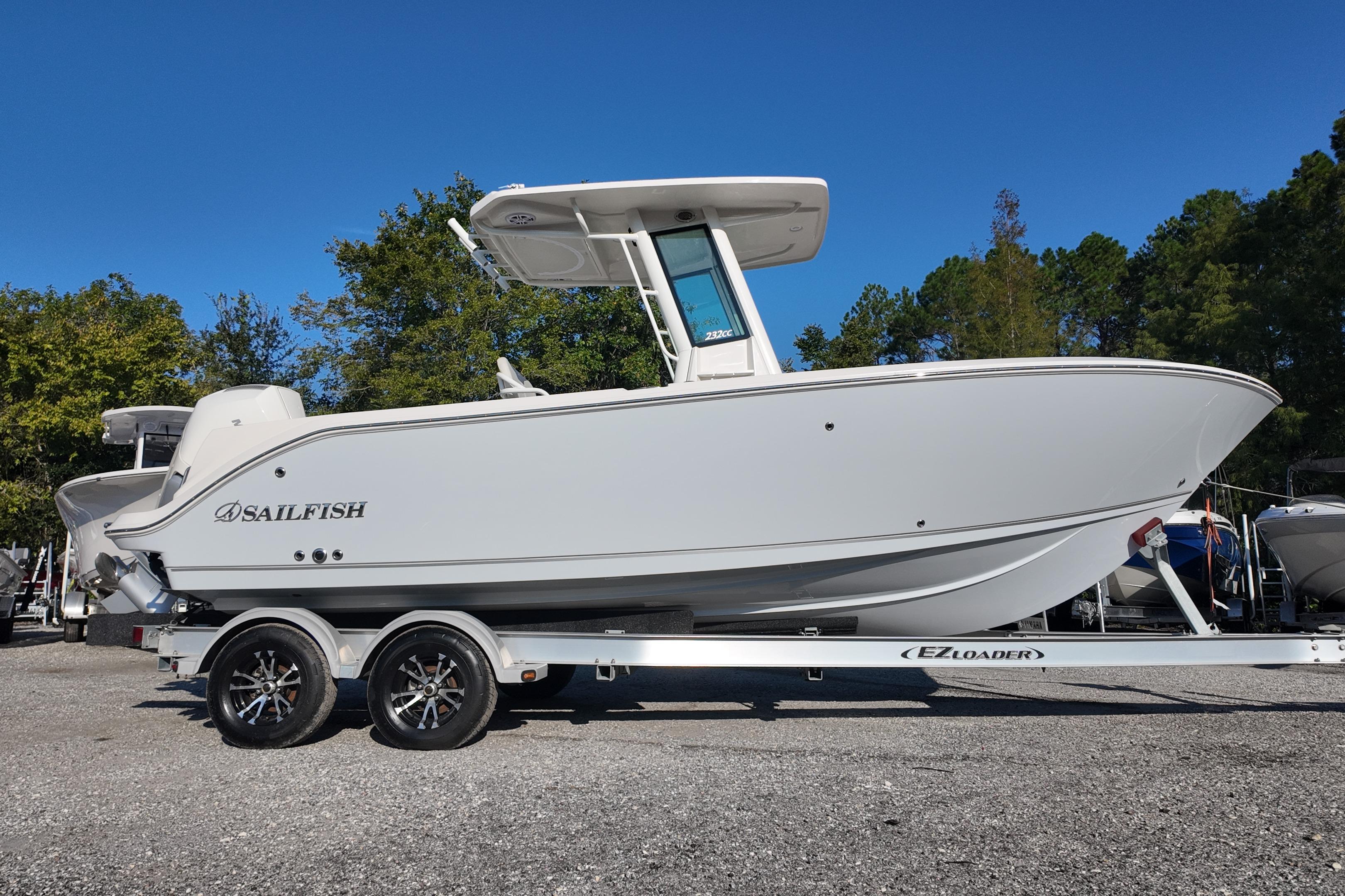 2026 Sailfish 232 CC boat on trailer, side view, outdoors with trees in background.