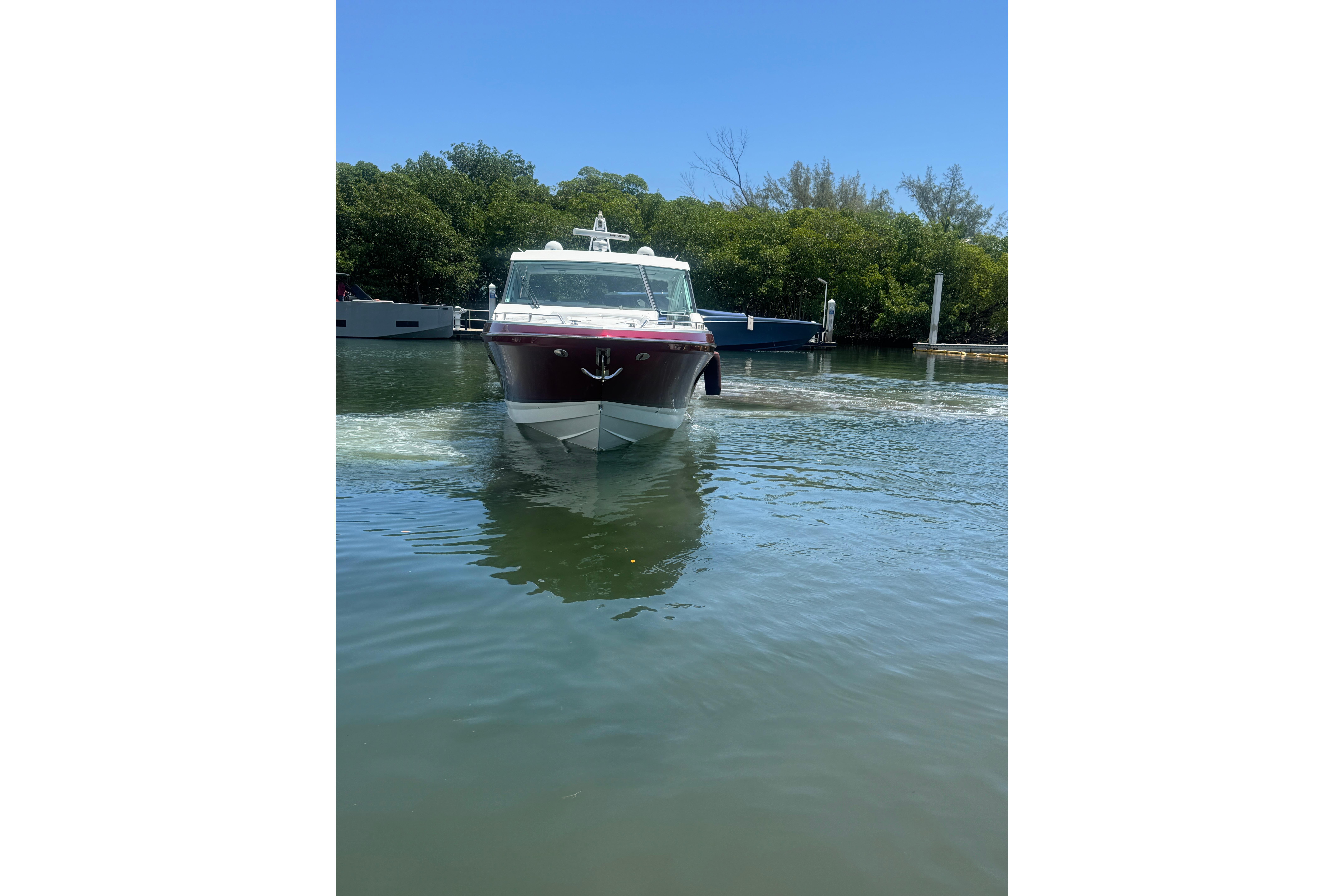 2020 Formula 430 Super Sport Crossover boat cruising on calm water near a dock.