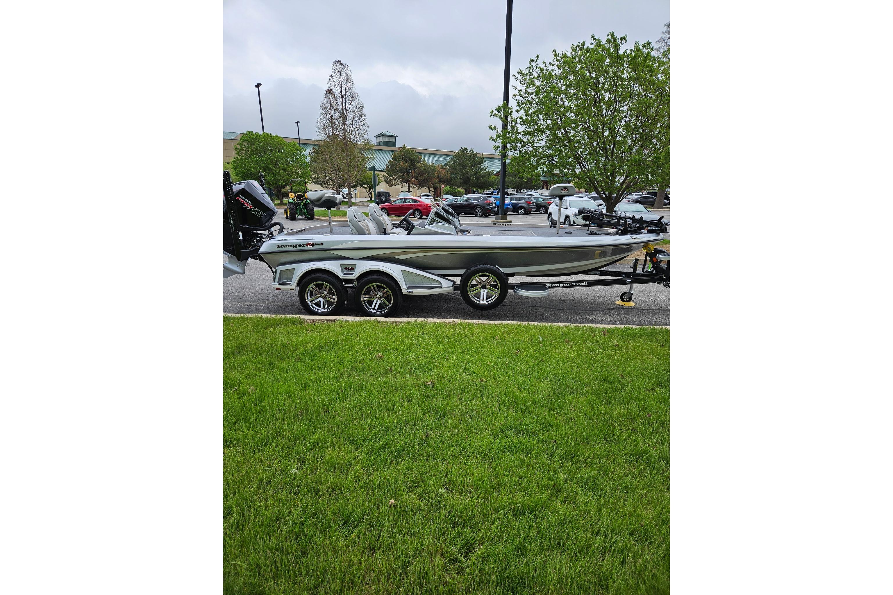 2026 Ranger Z521R Cup-Equipped boat on trailer, parked outdoors near green grass.