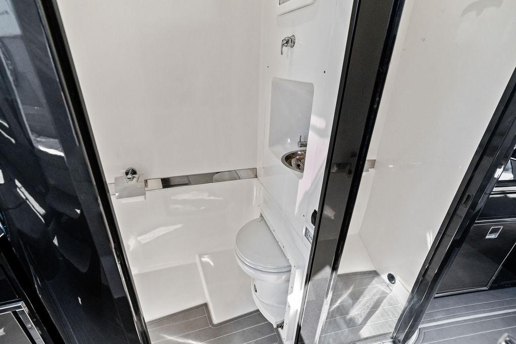 Modern bathroom in 2022 Midnight Express 43' Solstice boat, featuring sleek design and compact amenities.