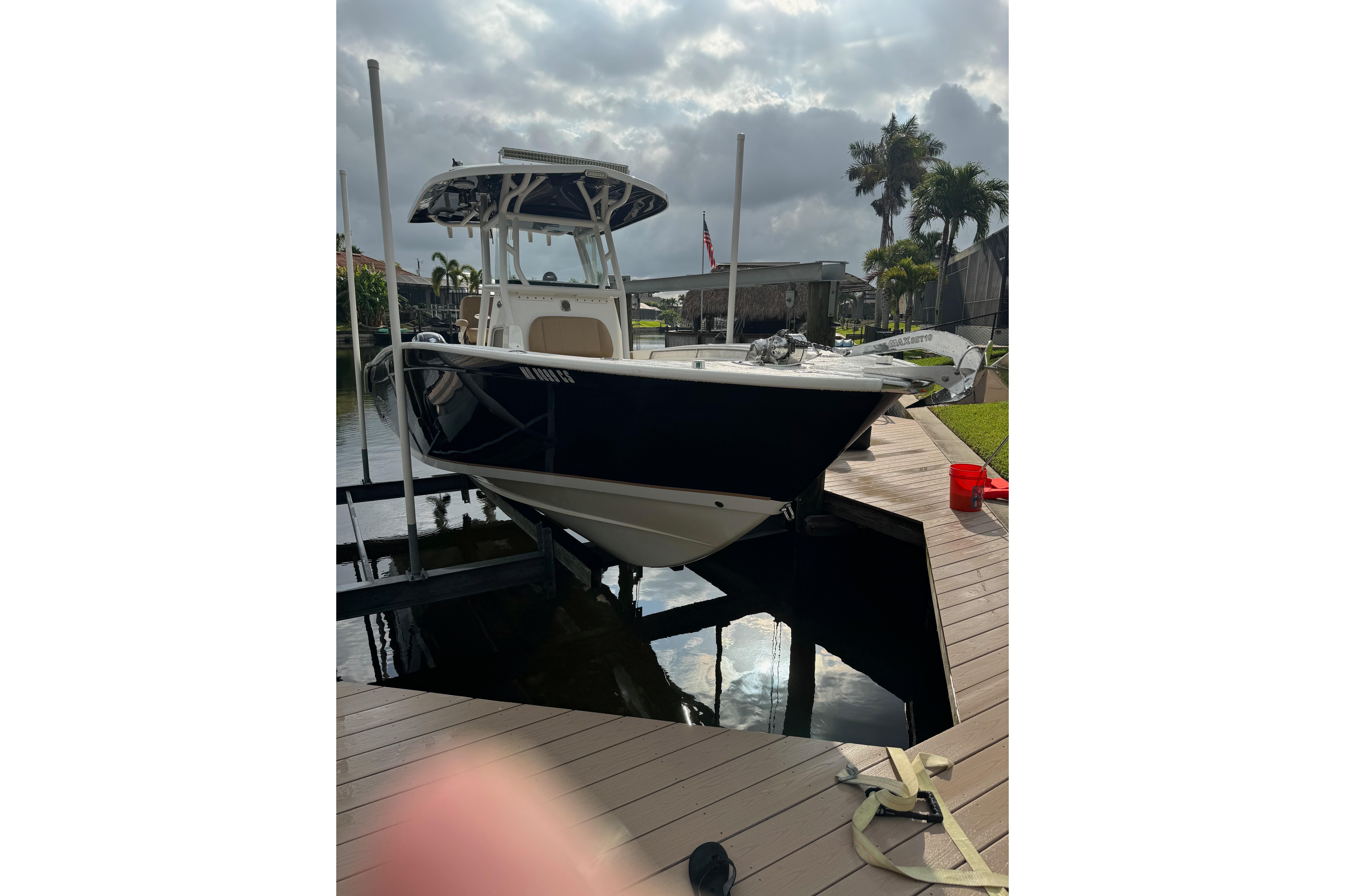 2019 Cape Horn 27 XS boat docked on a sunny day, surrounded by palm trees.