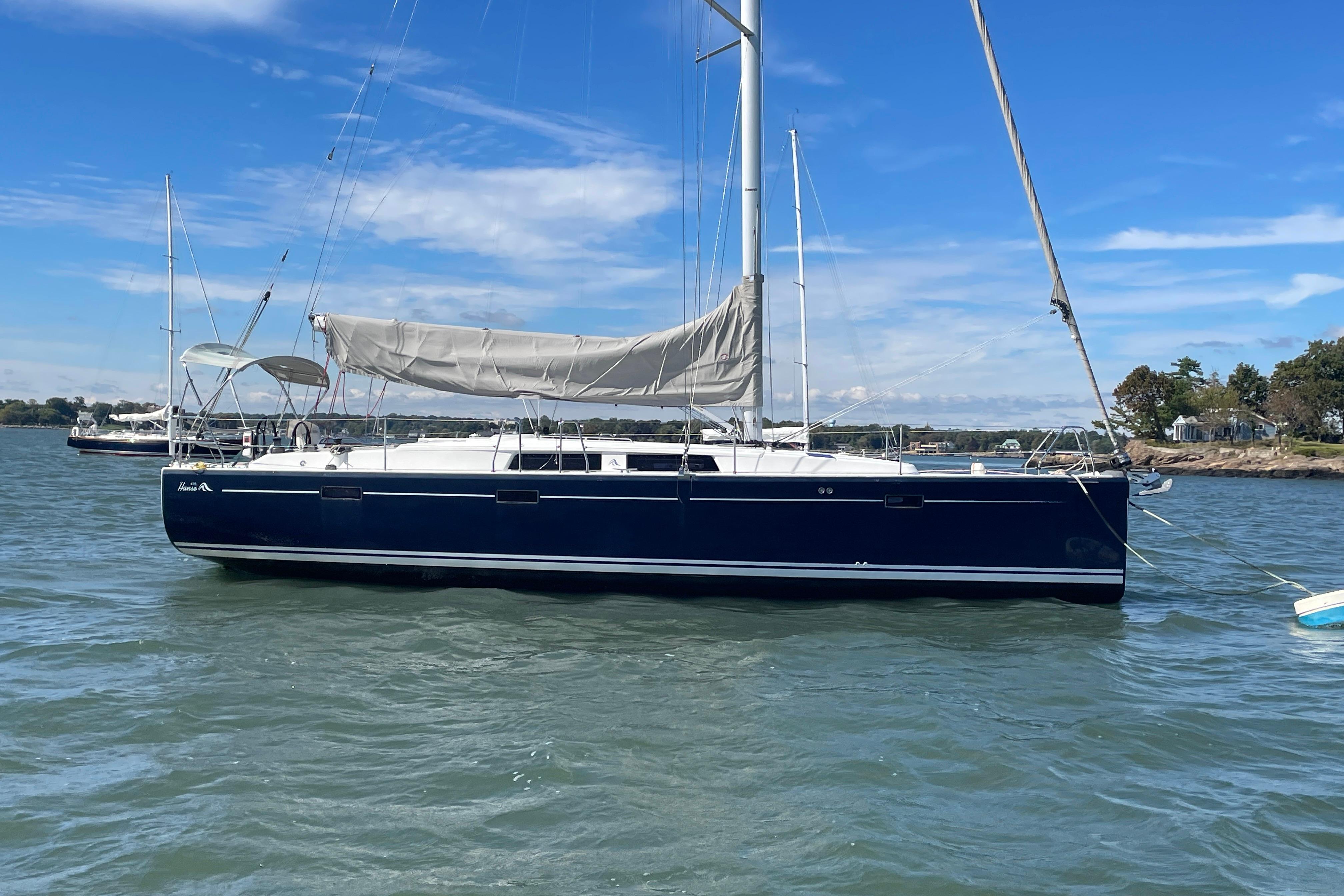 2014 Hanse 415 sailboat anchored on calm water under a clear blue sky.
