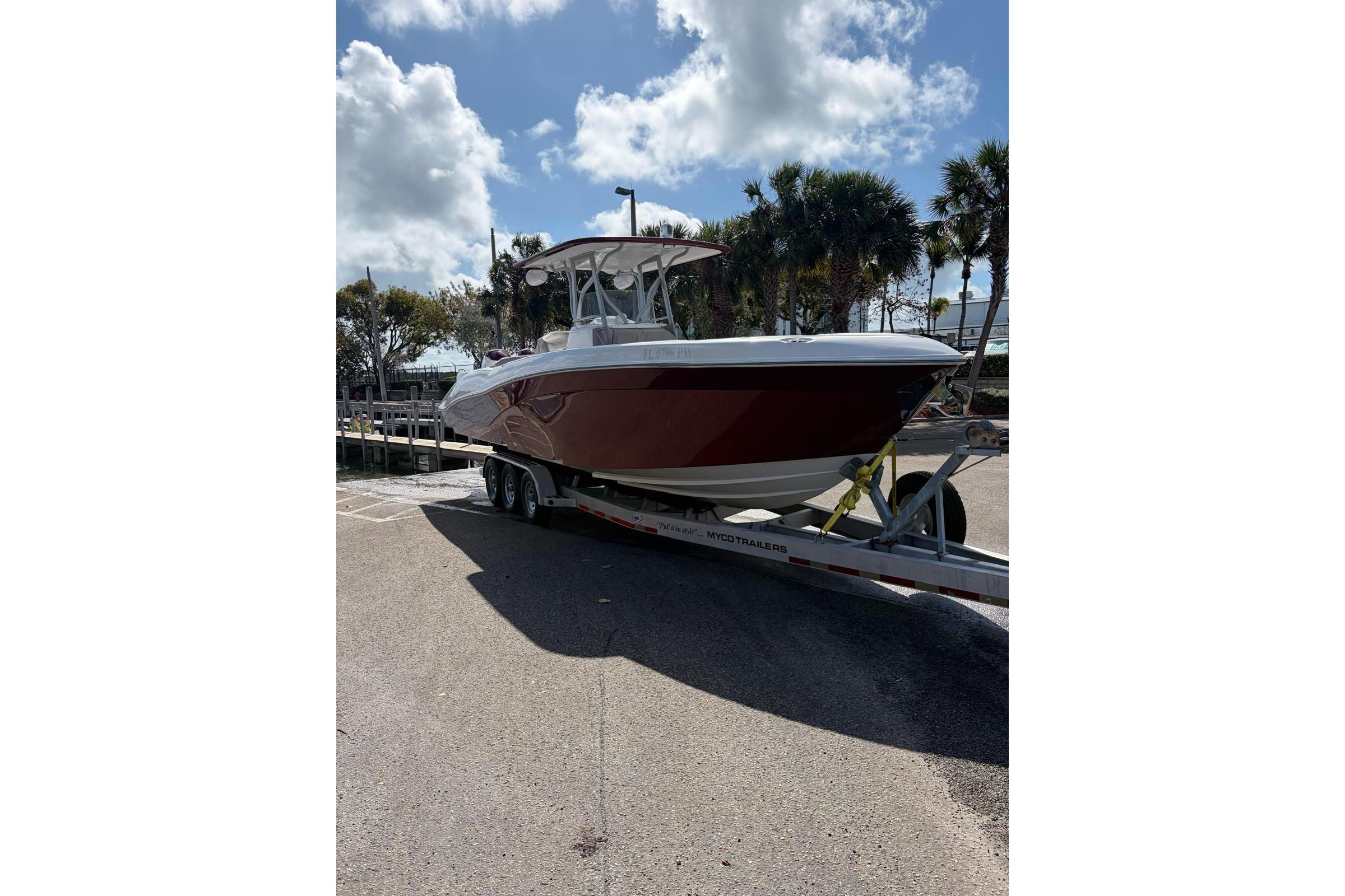 2015 Deep Impact 33 boat on trailer under a partly cloudy sky.