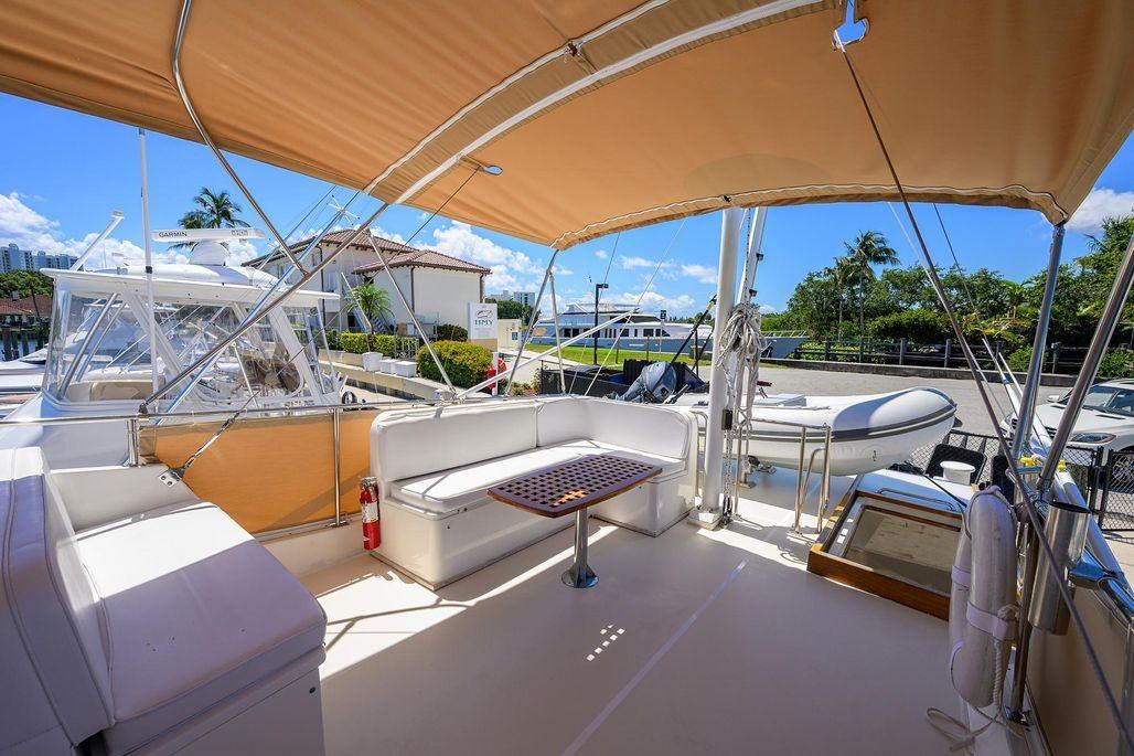Spacious deck of 1999 Grand Banks 42 Europa yacht with seating and canopy.