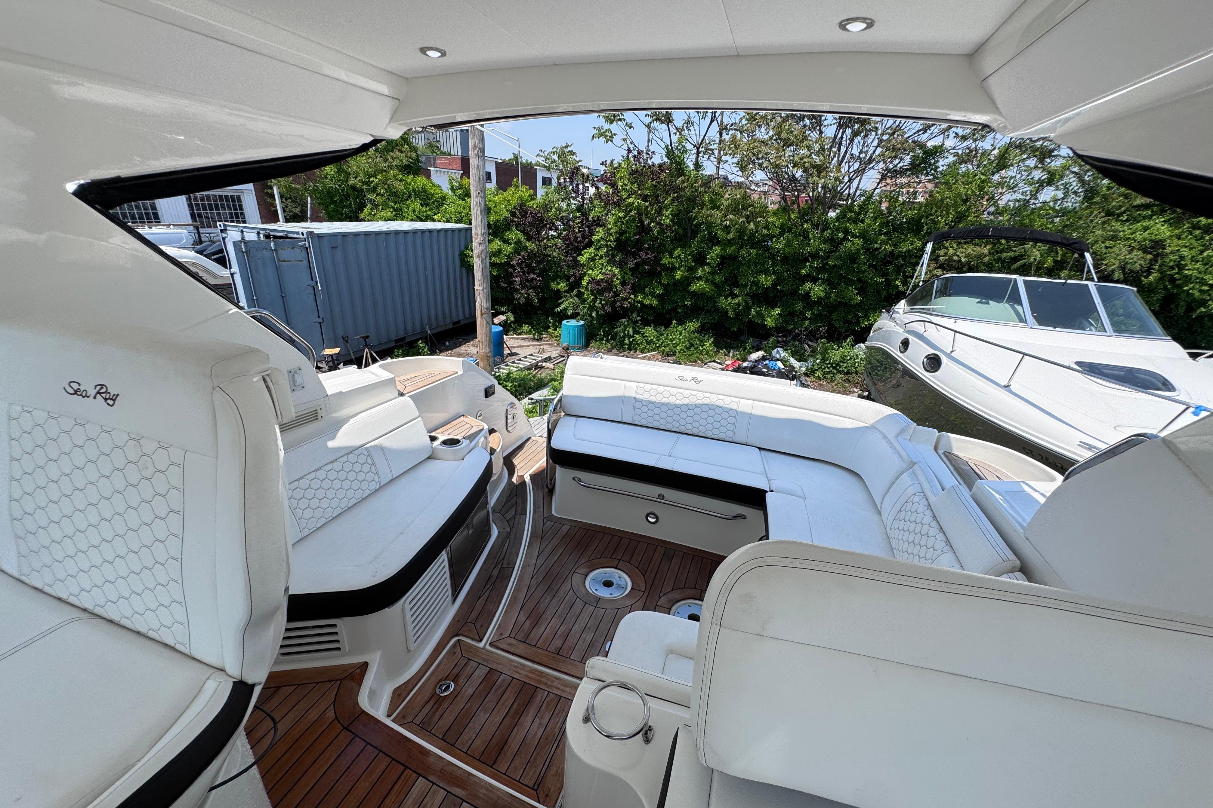 2019 Sea Ray Sundancer 350 yacht interior with white seating and wooden flooring.