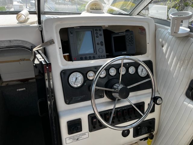 The image shows the helm of a 1998 Sport-Craft 252 Sport Fish boat with instruments and steering wheel.