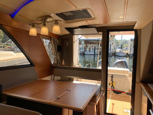 Interior of 2021 Cutwater C-32 CB boat, featuring a dining area and view of the marina.