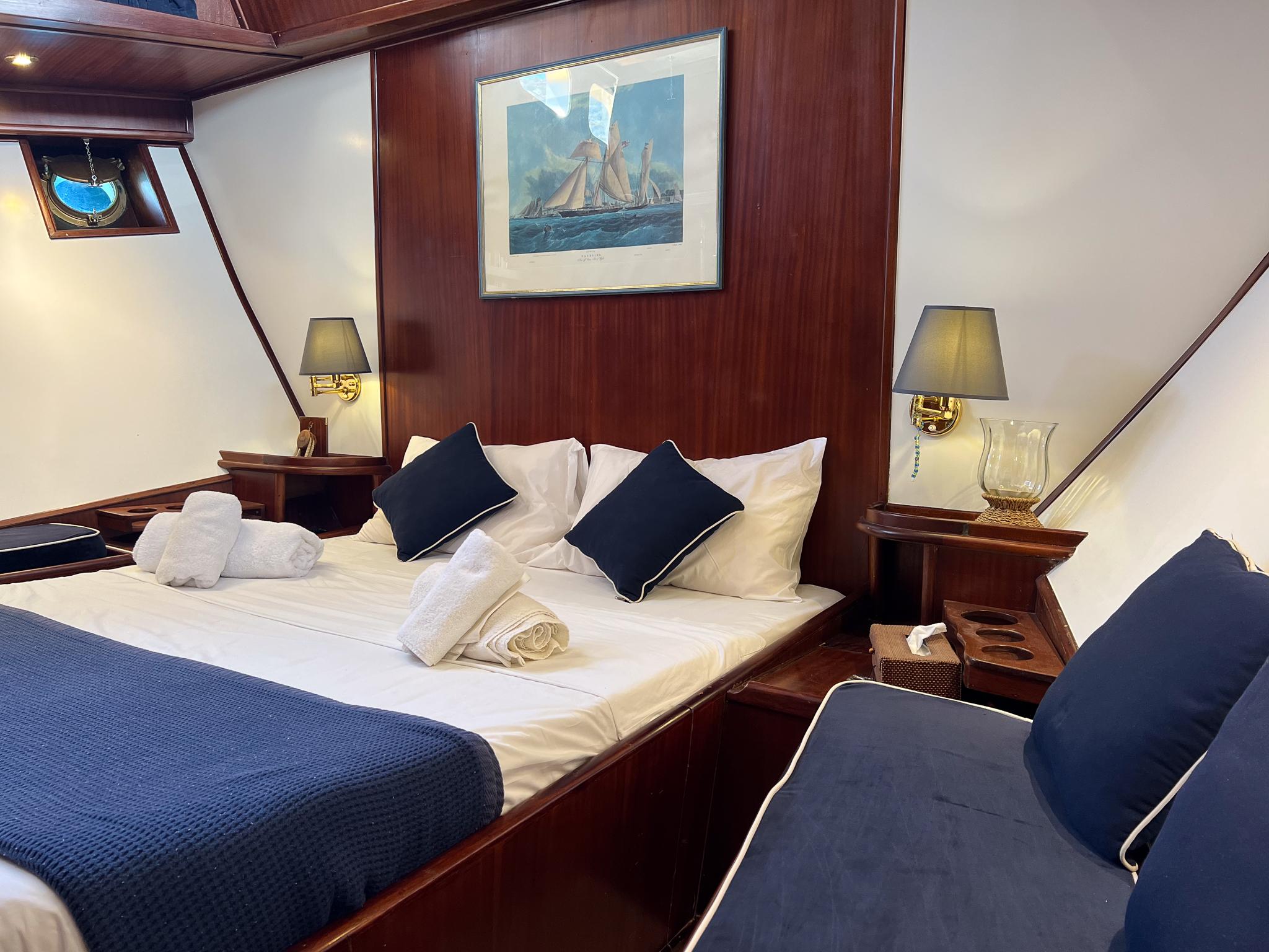 Luxurious cabin interior of 1969 Psarros Shipyard yacht with elegant bedding and decor.