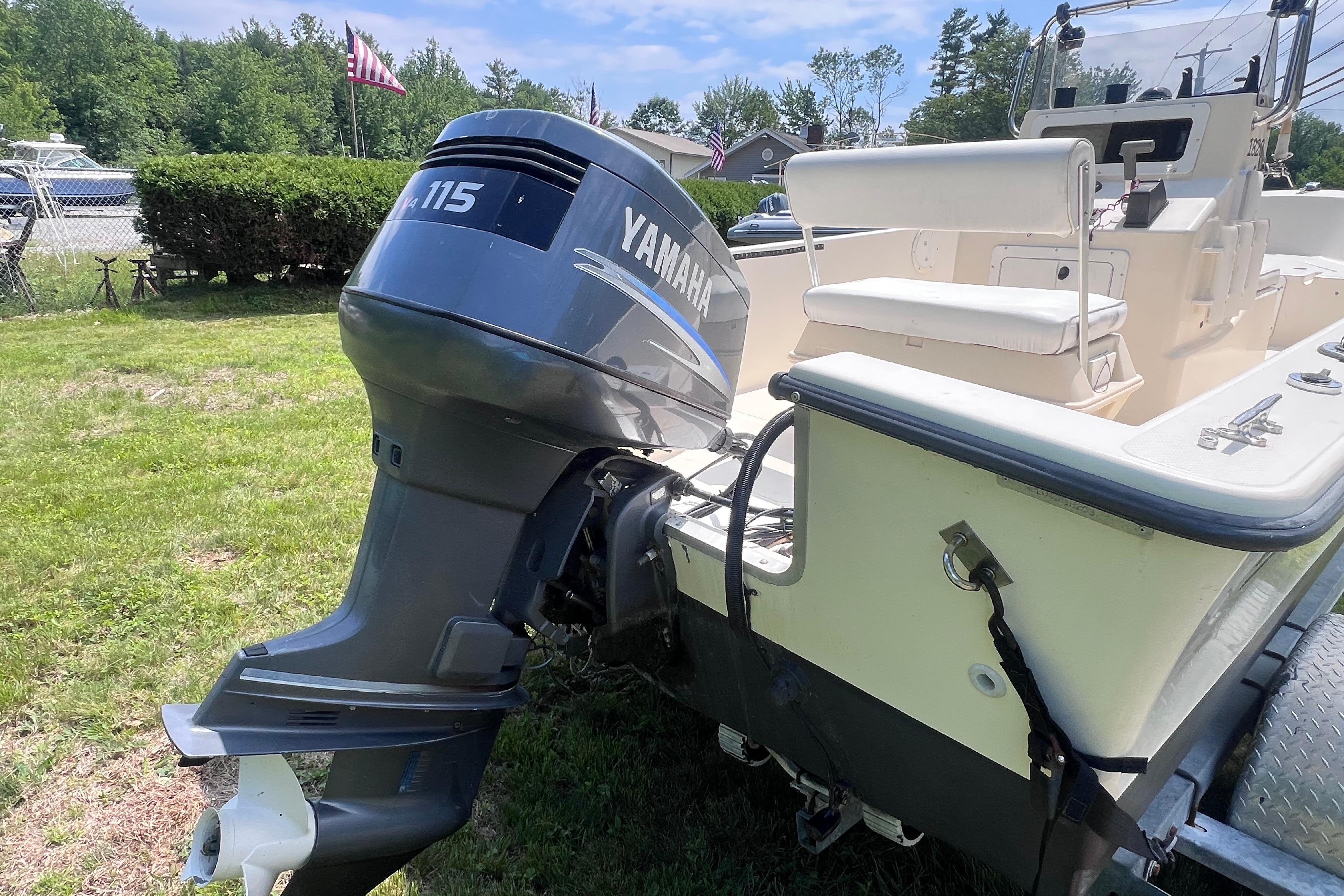 2003 May-Craft 1820CC boat with Yamaha 115 outboard motor on grassy area.