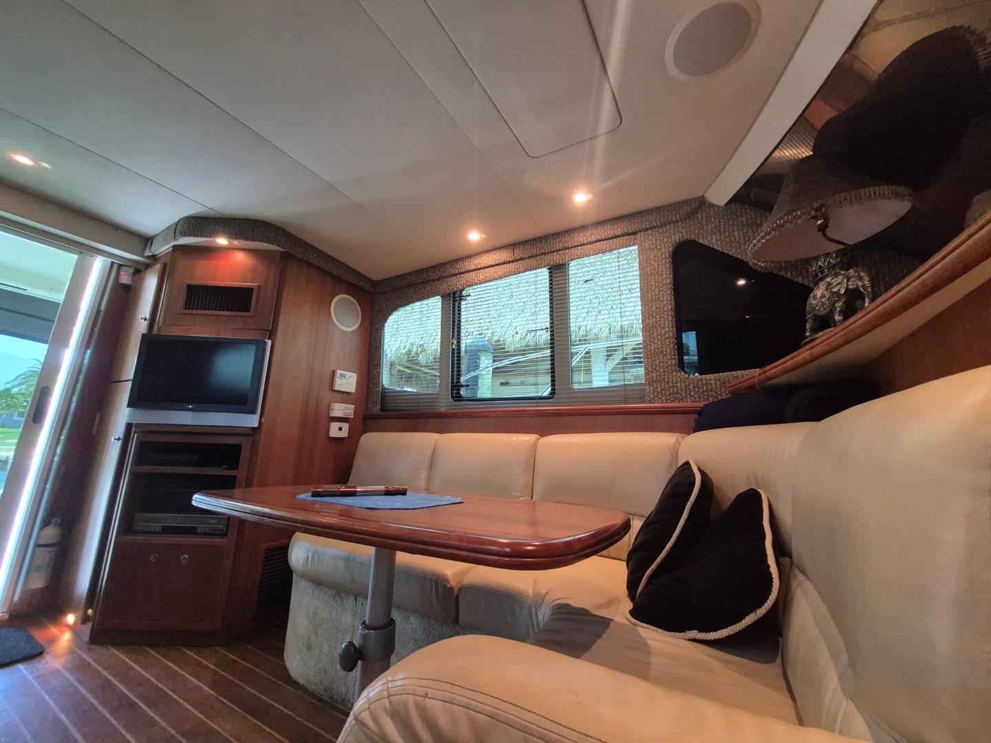 Interior of 2002 Silverton 38 Convertible yacht with cozy seating and entertainment area.