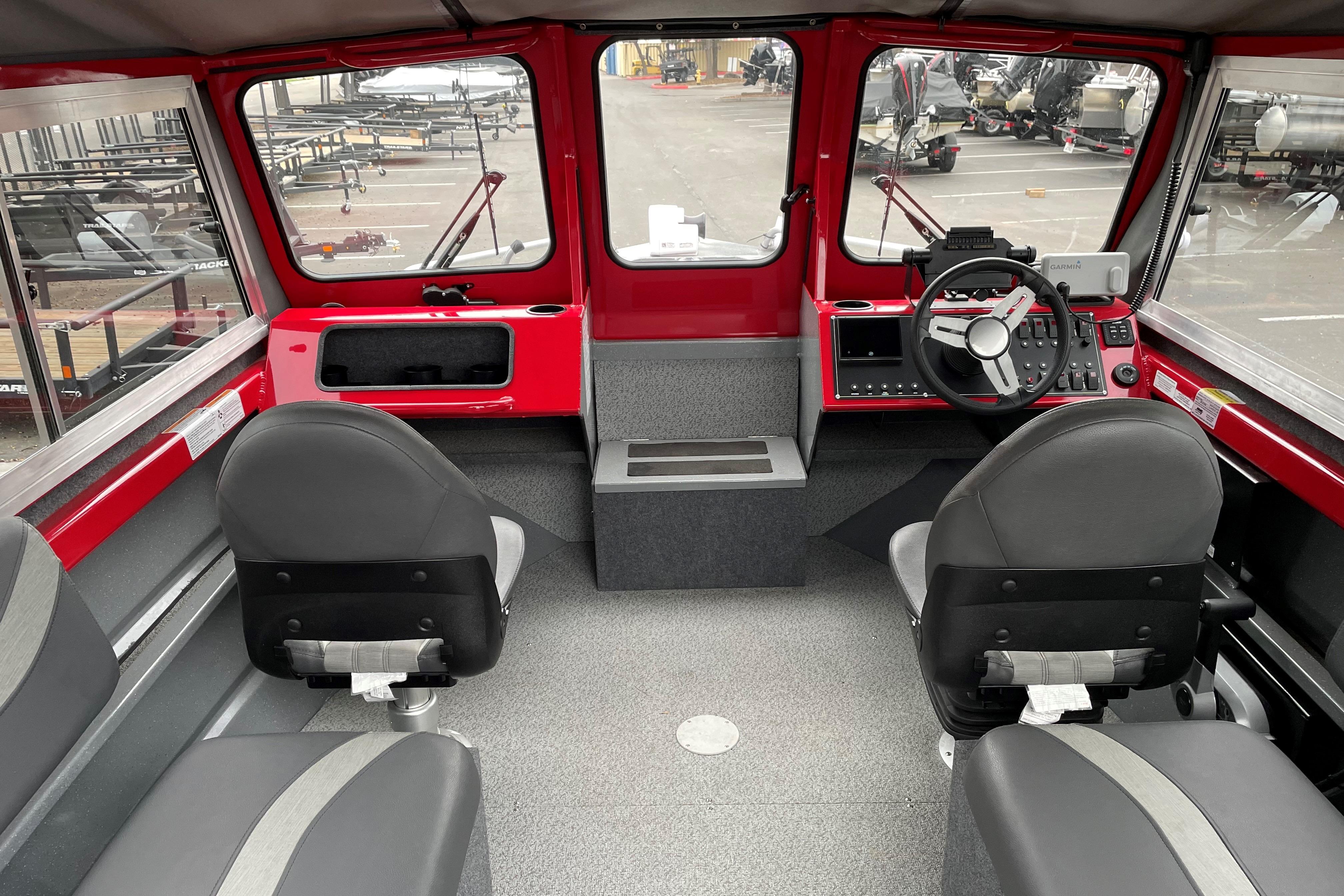 Interior of 2024 Spartan 200 Astoria boat with red dashboard and gray seating.