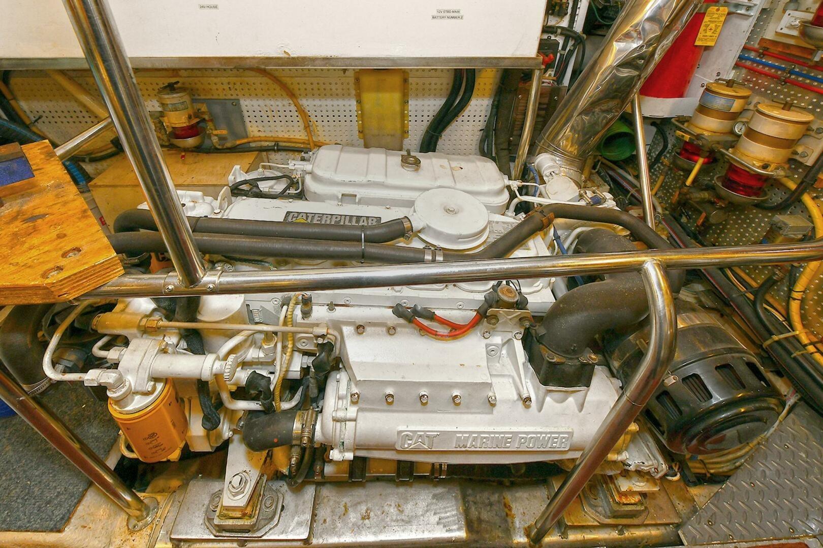 Engine room of 2002 Grand Alaskan Flushdeck yacht featuring a Caterpillar marine engine.
