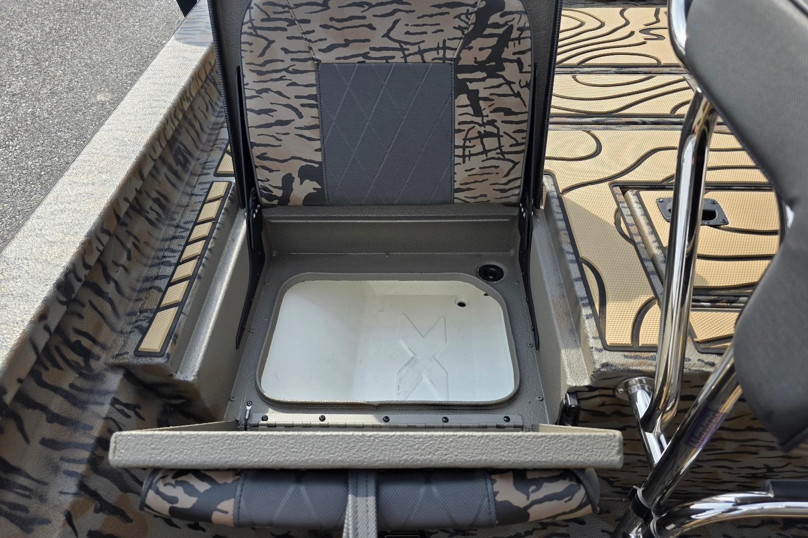 2026 Xpress H22B Bay boat seat storage compartment with camouflage design.