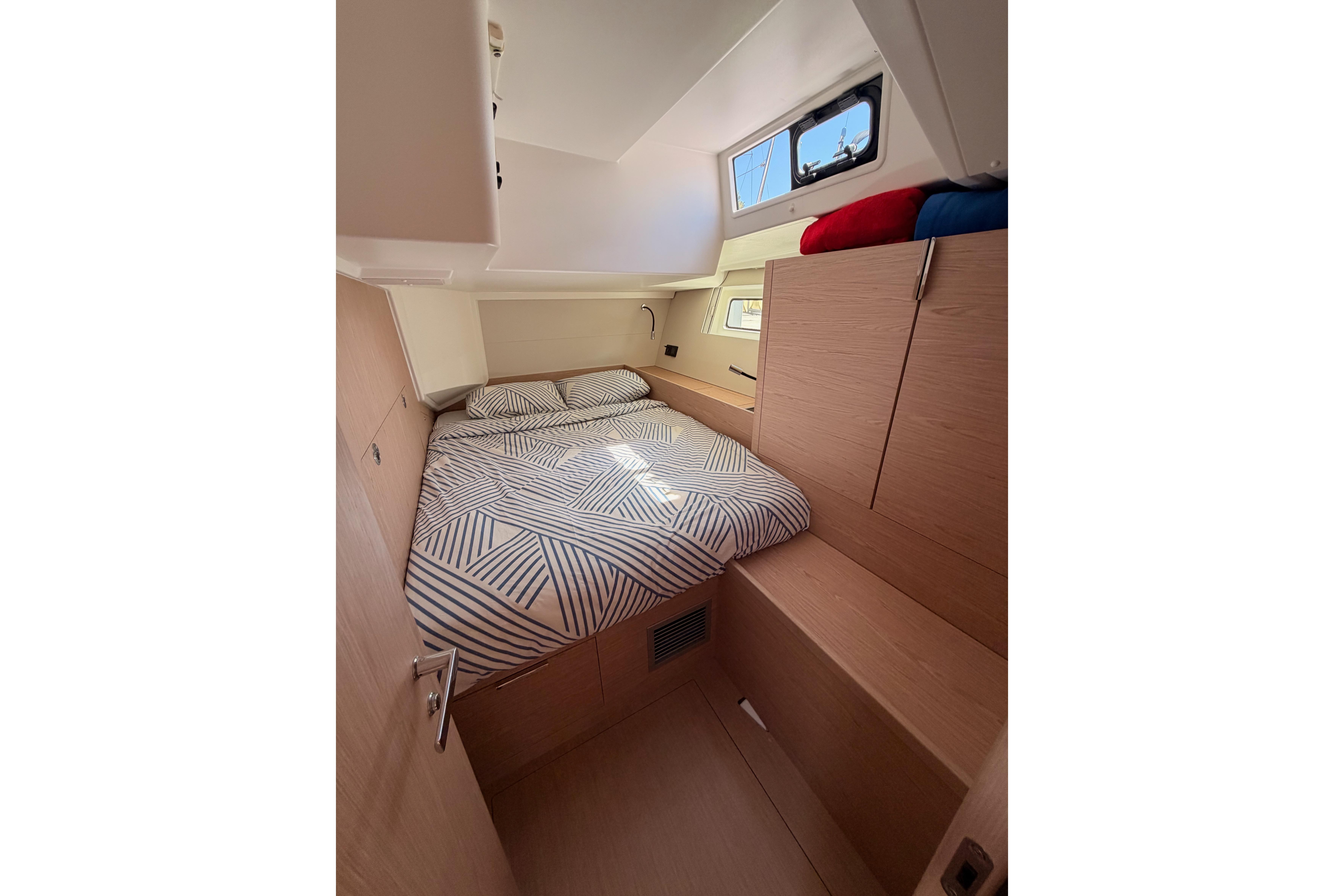 Cozy cabin interior of 2022 Beneteau Oceanis Yacht 54 with modern bedding.