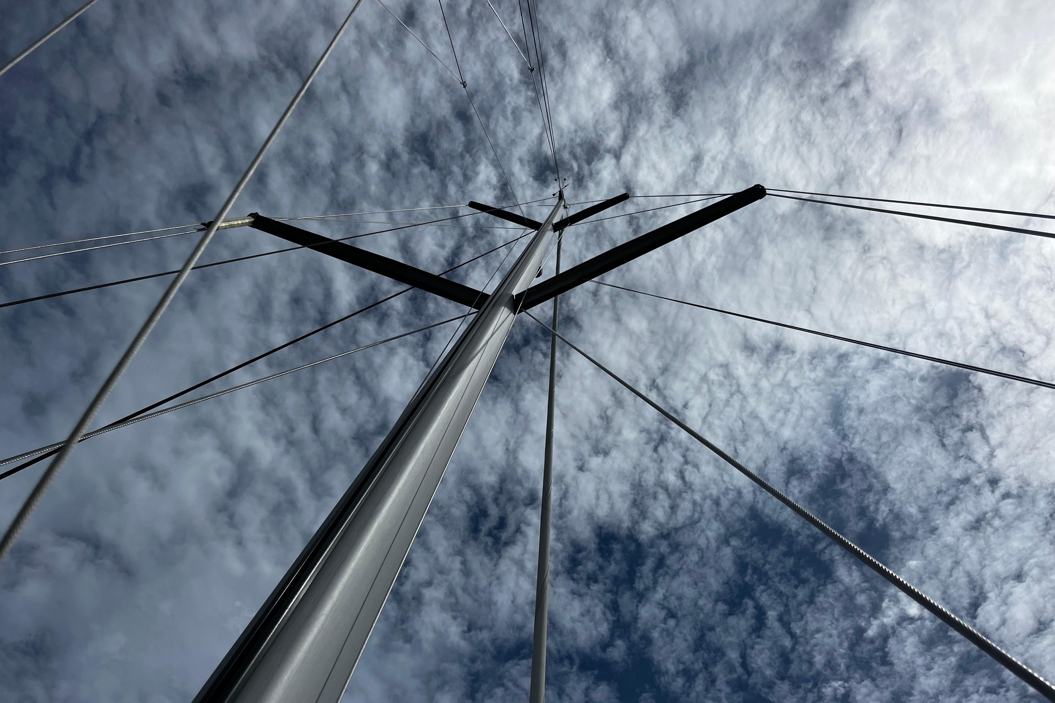 Mast of 2004 Hanse 411 sailboat against a cloudy sky.