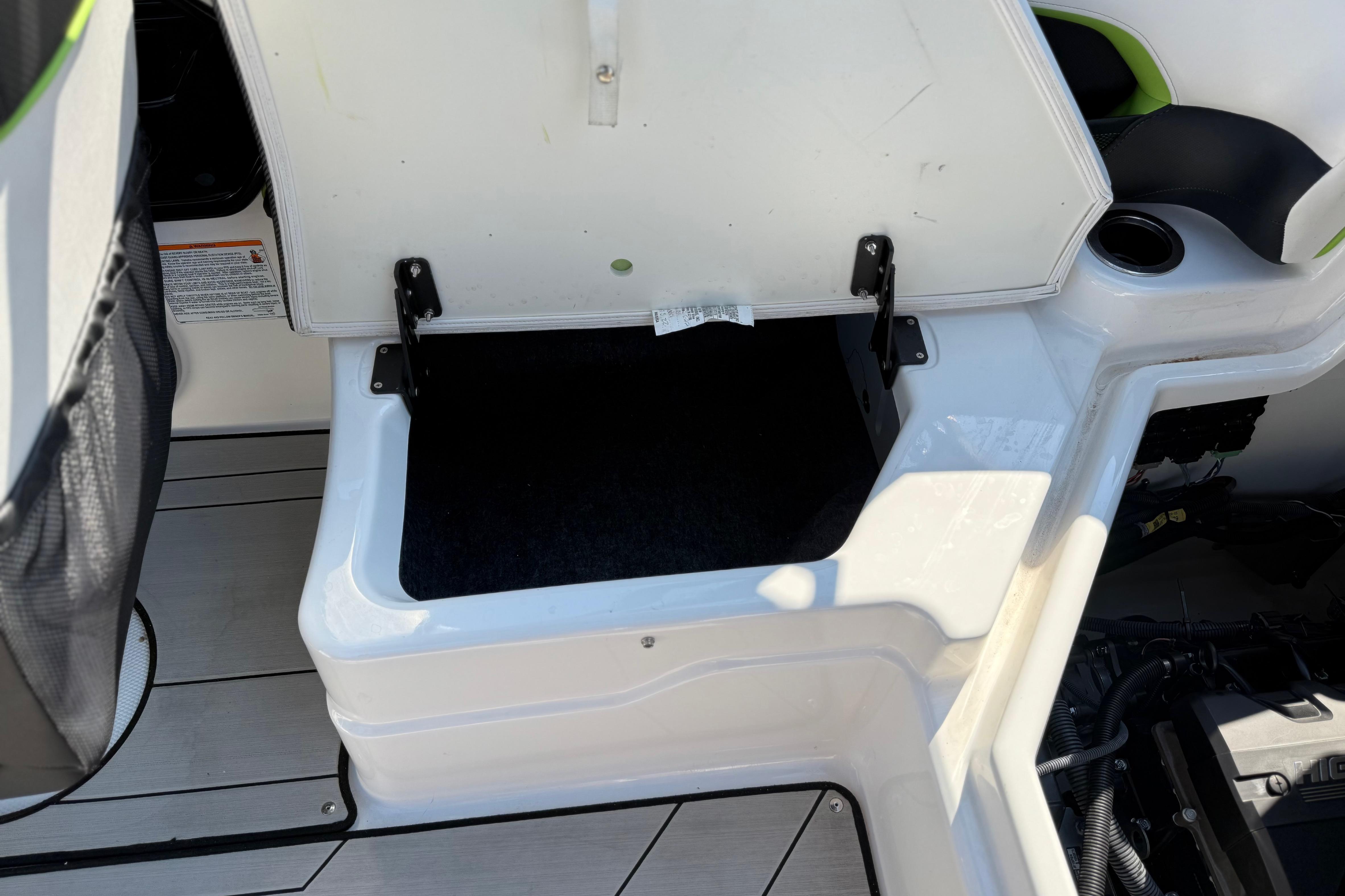Open storage compartment on 2022 Yamaha Boats 212XE, showcasing interior space and design.