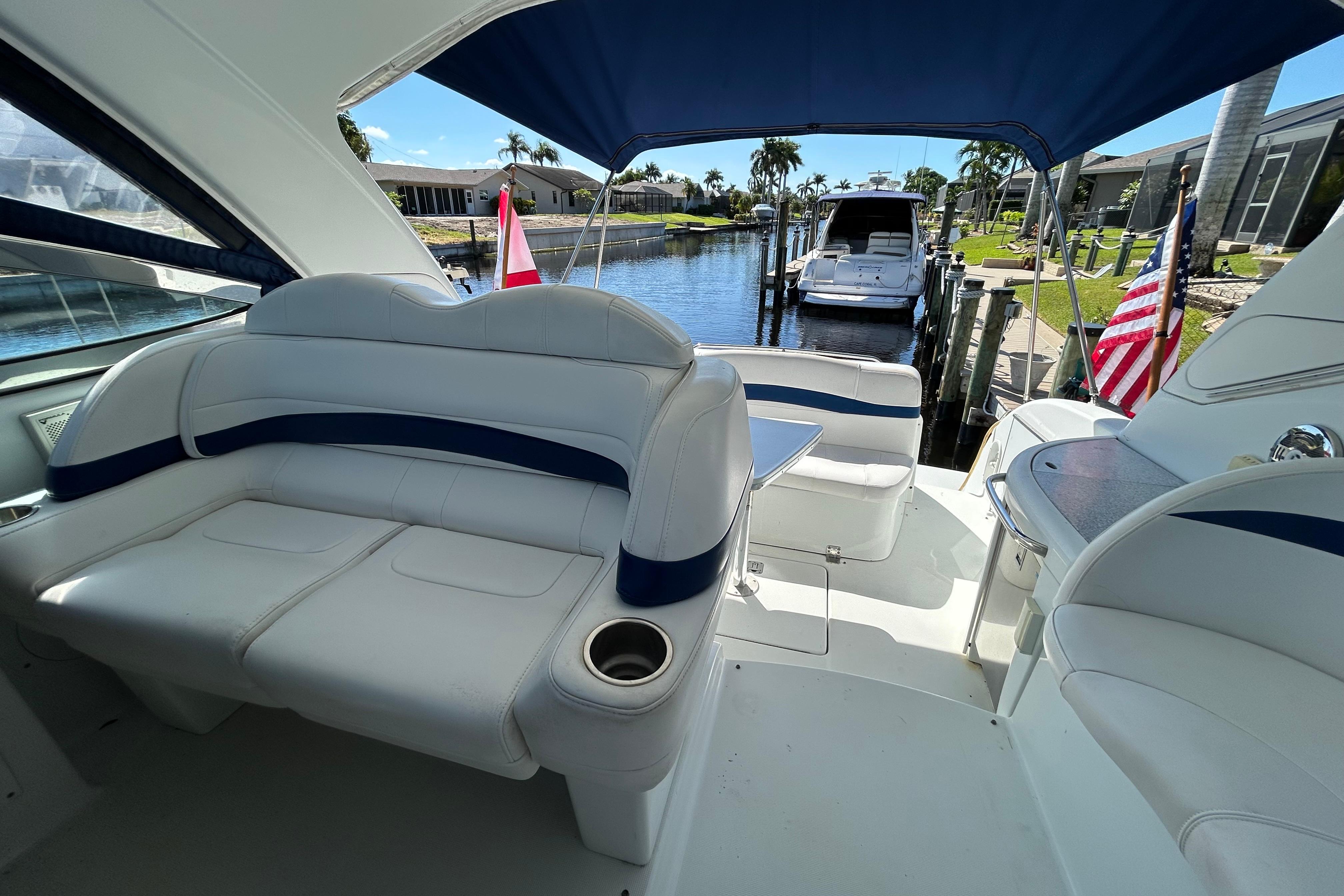2008 Formula 34 Performance Cruiser interior with white seating, docked near waterfront homes.