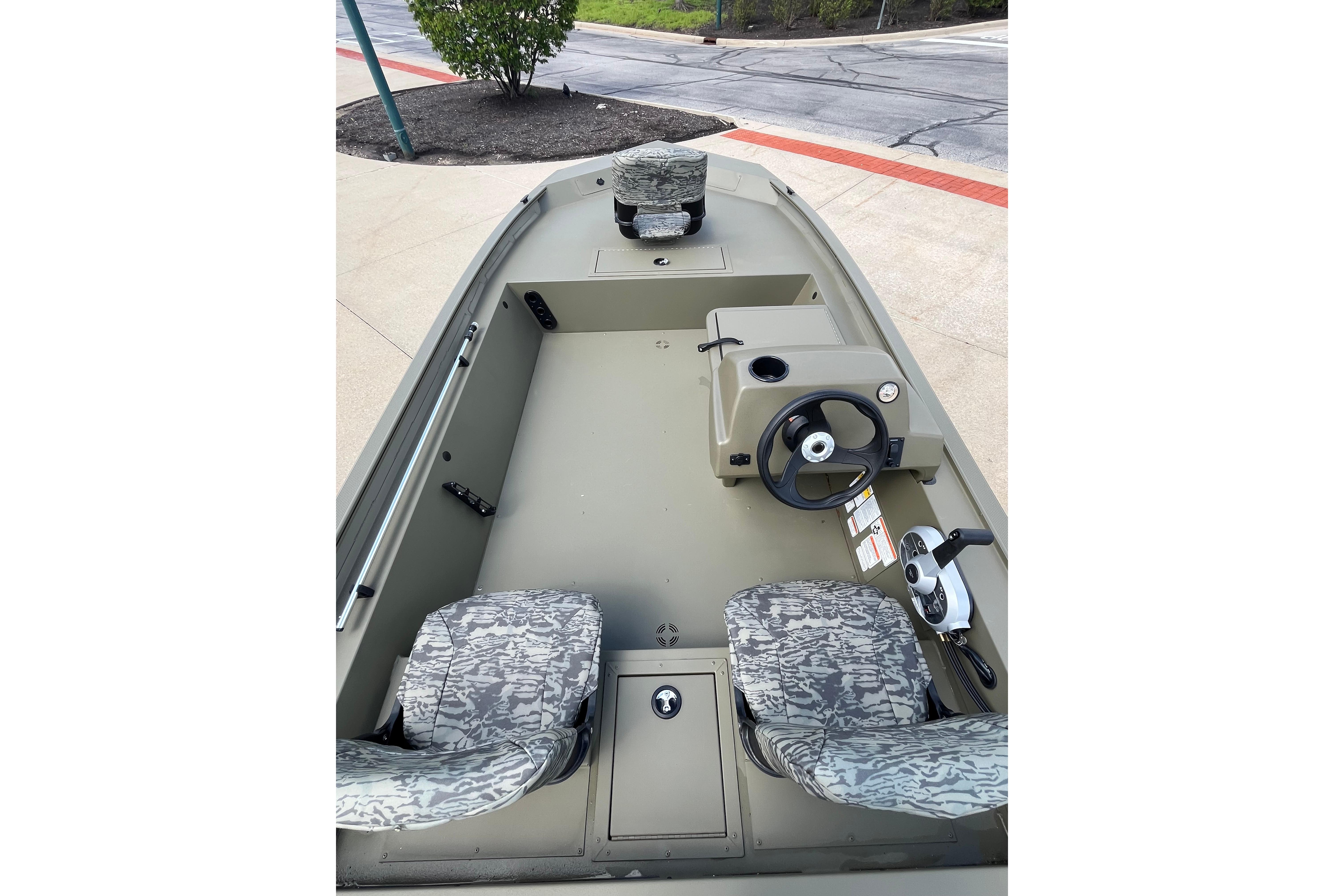 2026 Tracker Grizzly 1754 SC boat interior with camo seats and steering console.