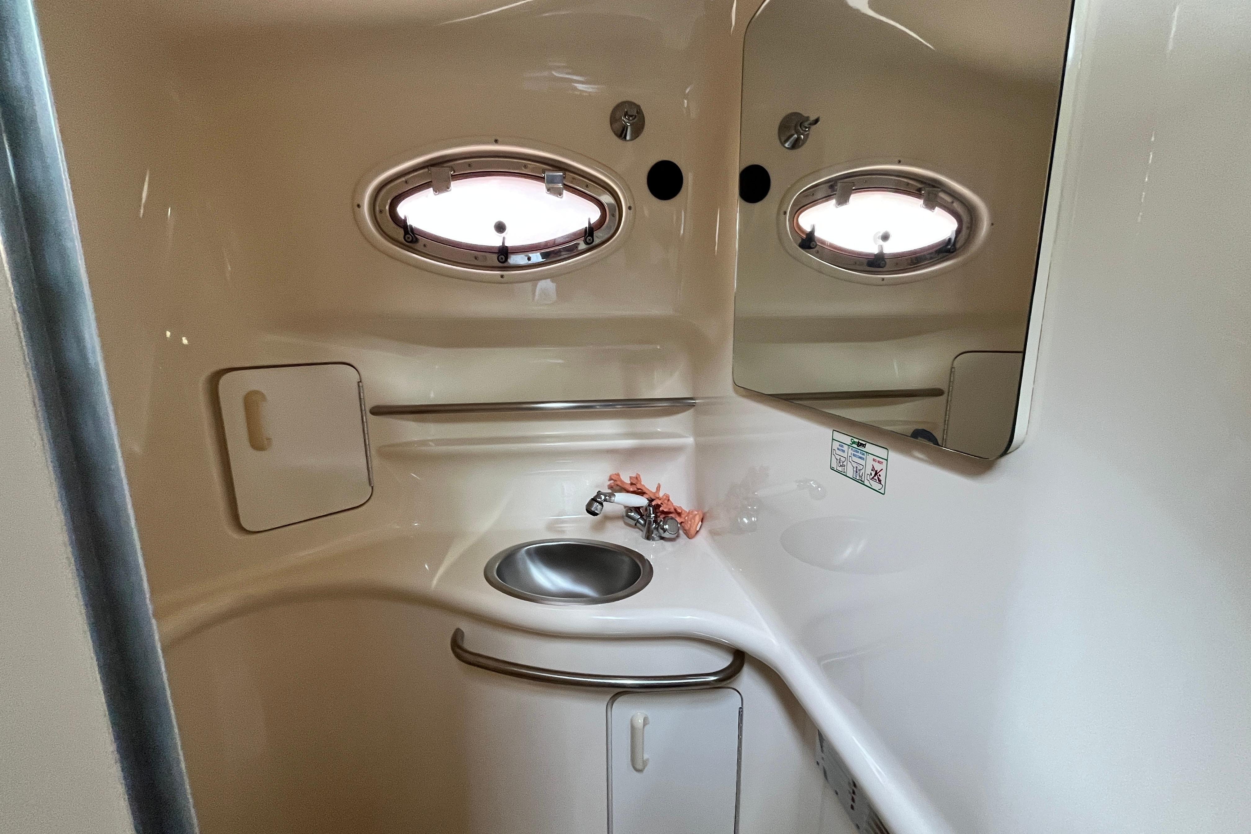 1995 Sea Ray Sundancer 330 bathroom interior with sink and porthole window.