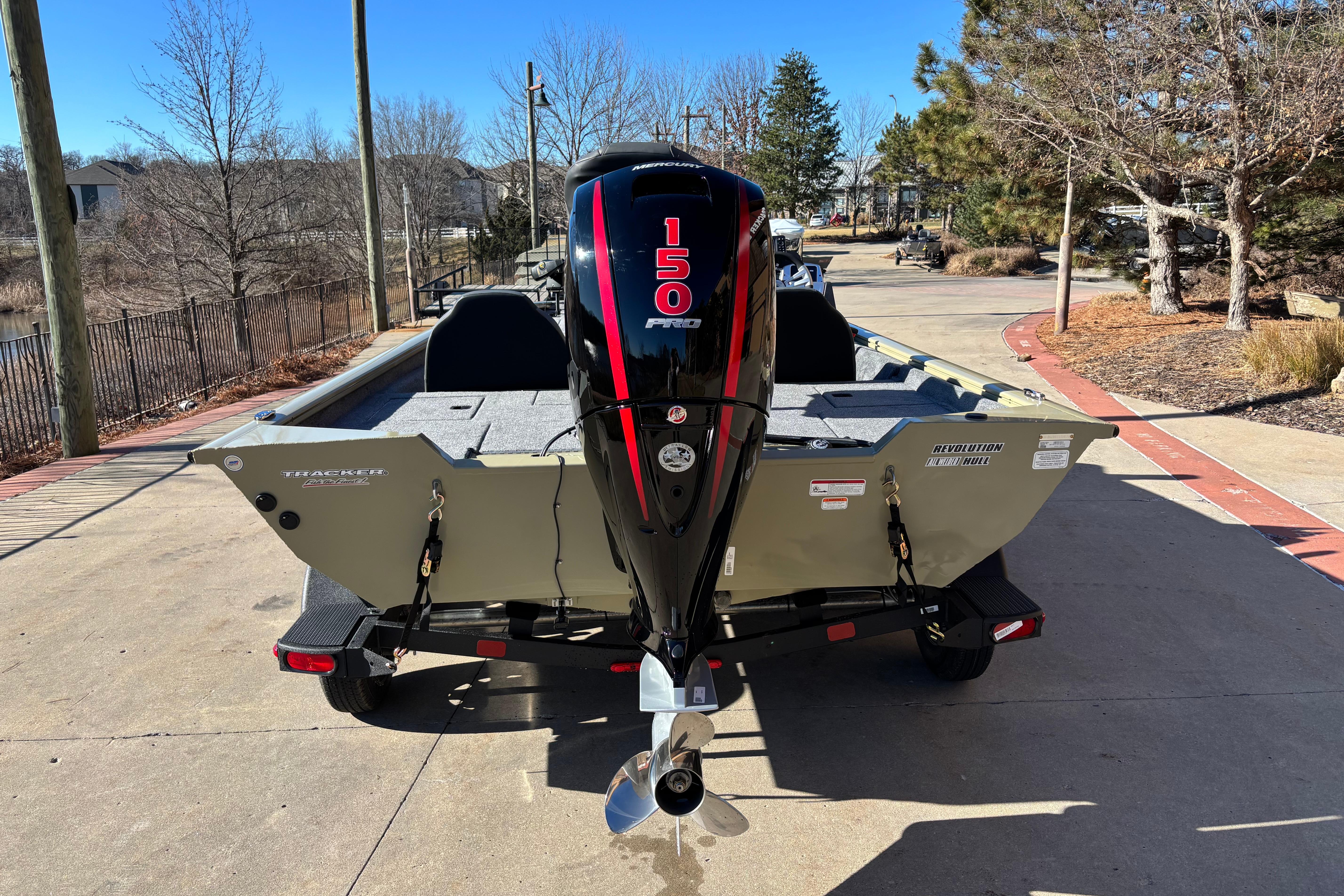 2026 Tracker Pro Team 195 boat with 150 HP engine, parked outdoors.