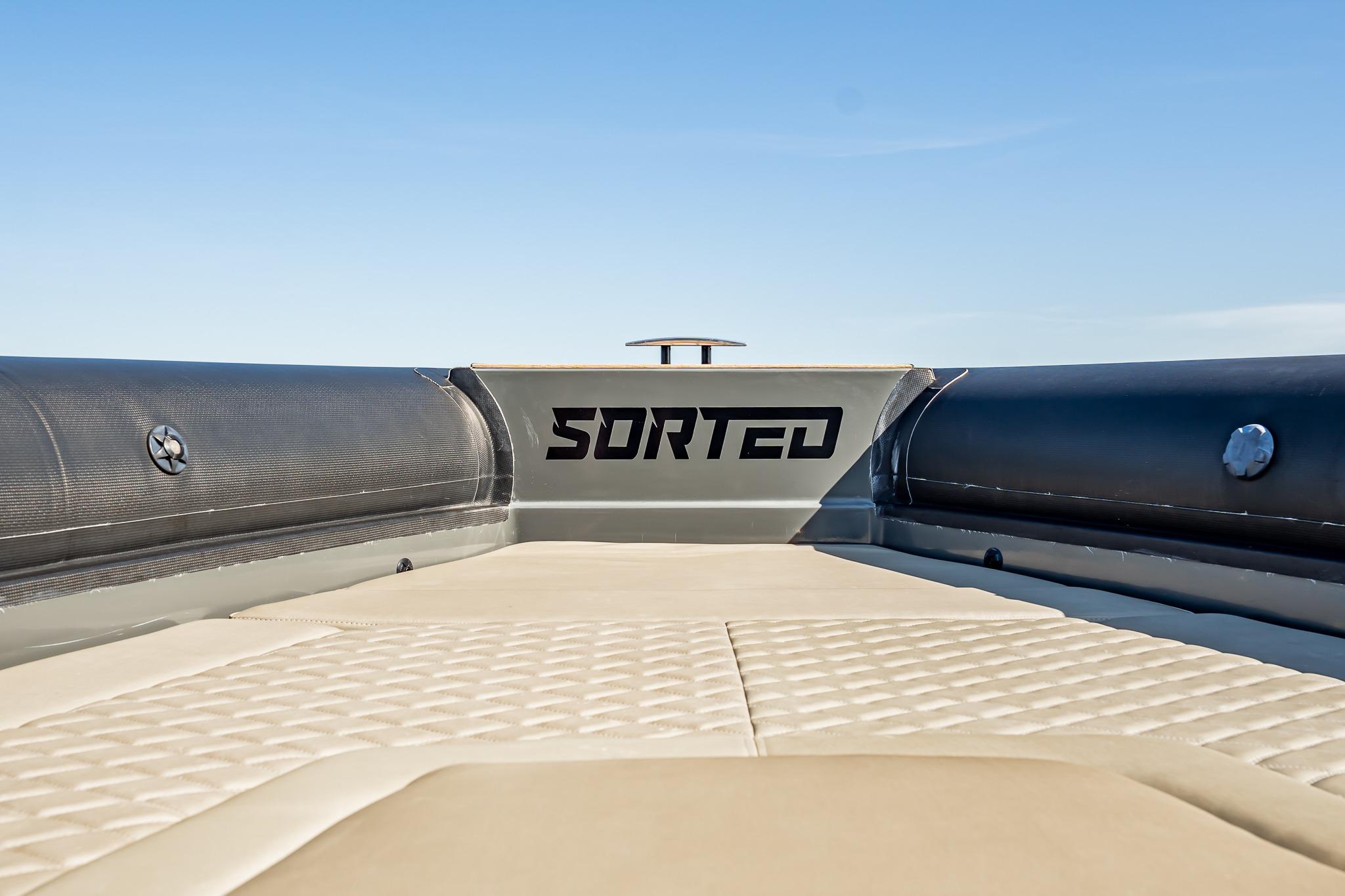 2023 Skipper-BSK 38NC boat deck with "SORTED" branding, featuring cushioned seating.