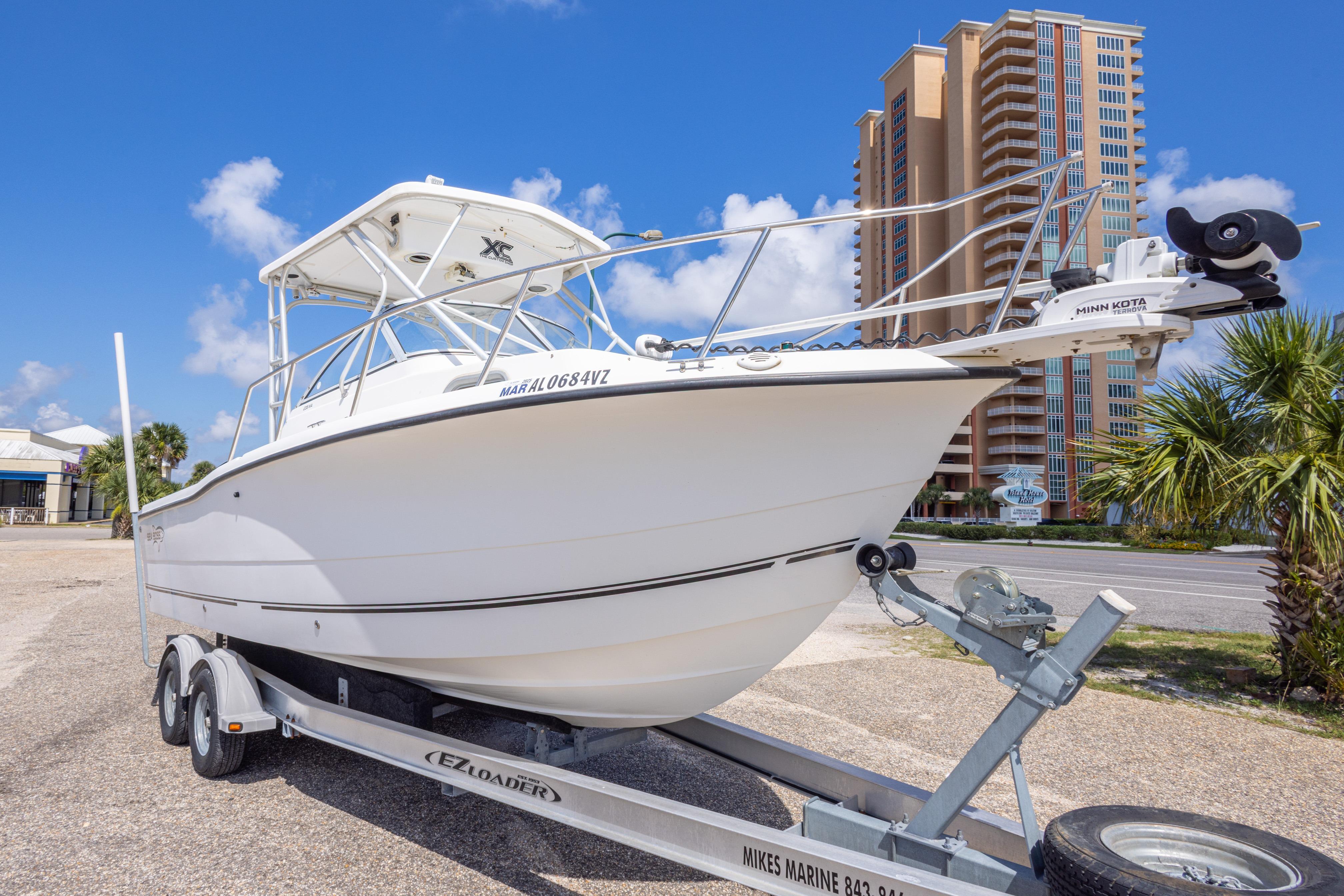 2007 Sea Boss 235 Walkaround boat on trailer, with a cityscape backdrop.