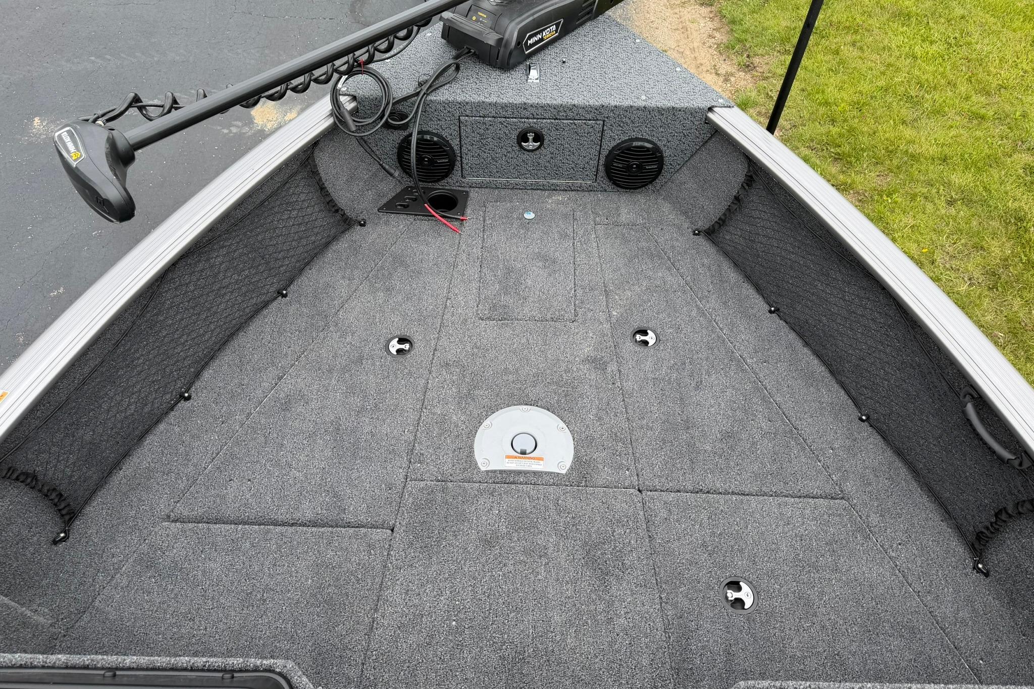 2027 Lund 1875 Impact XS Sport boat interior with carpeted deck and trolling motor.