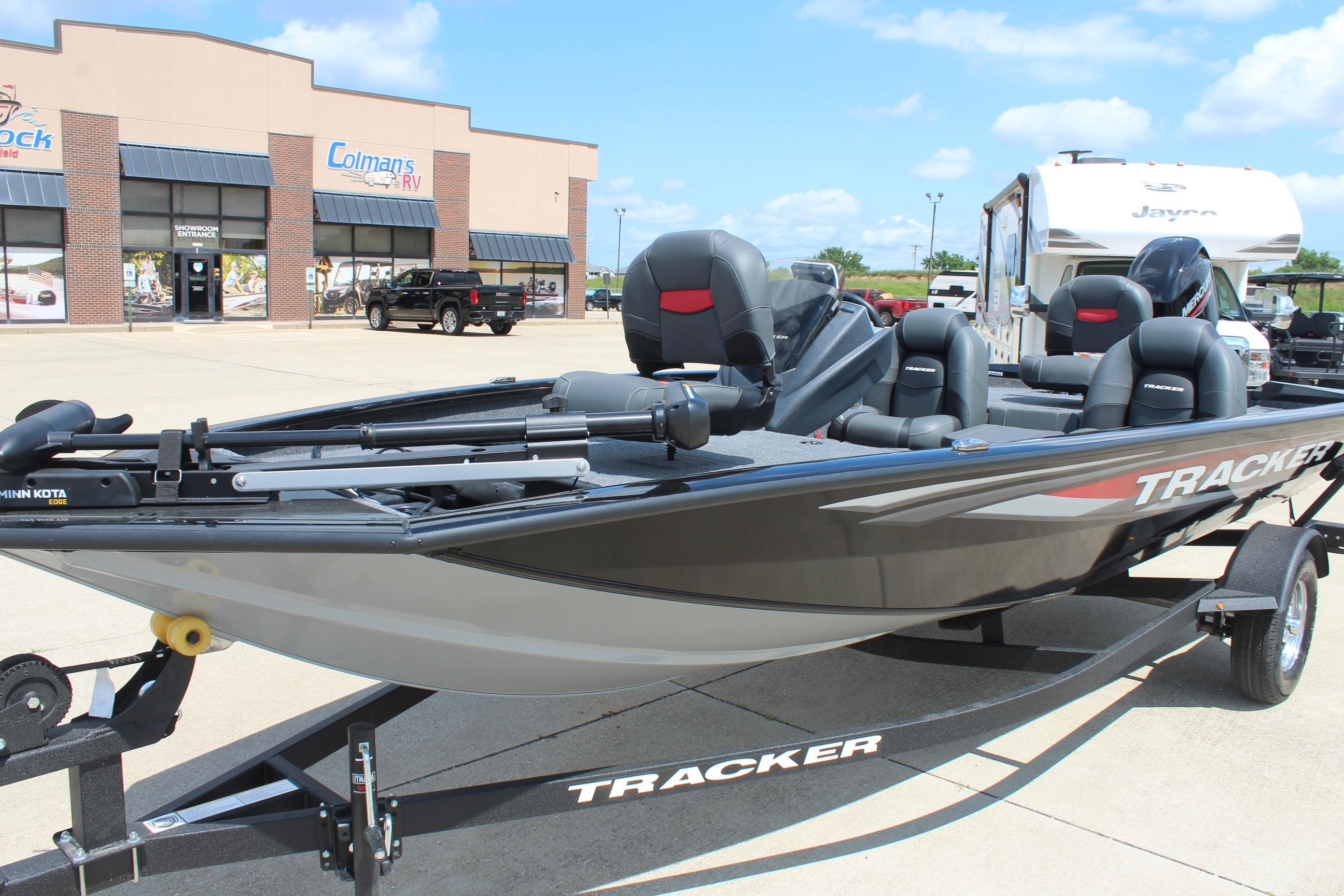 2026 Tracker Pro Team 175 boat on trailer, parked outside dealership under clear sky.