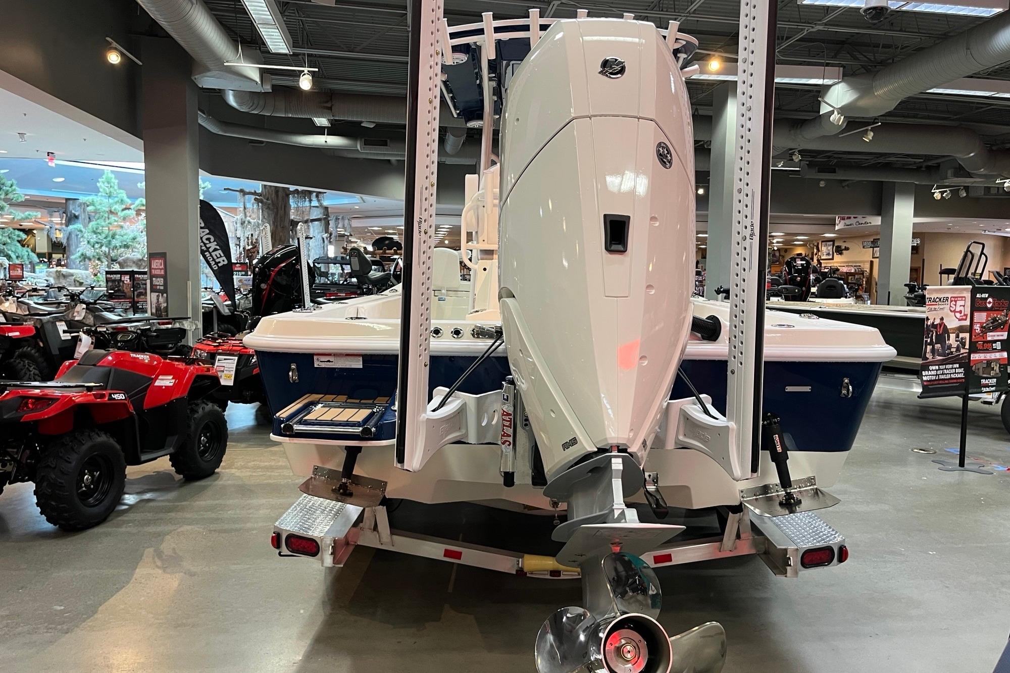 2026 Ranger 2510 Bay boat displayed indoors, featuring a powerful outboard motor.