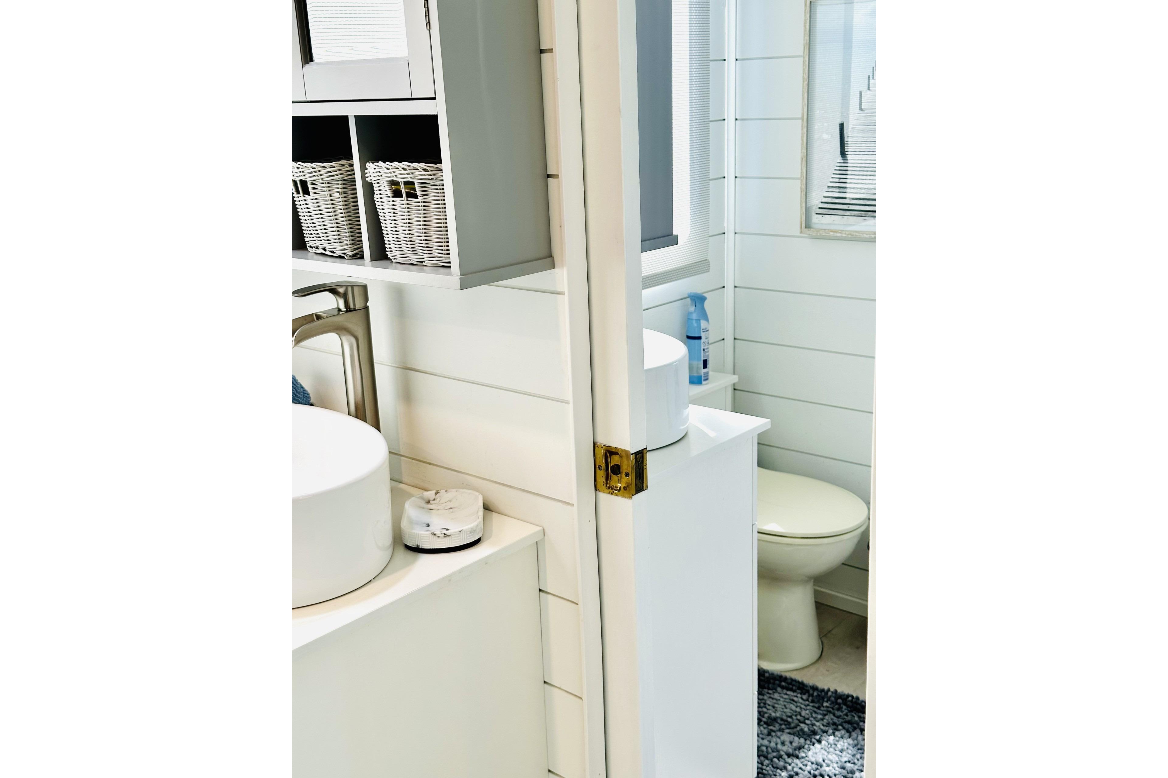 Bathroom interior of 1992 Sumerset 66 houseboat with modern fixtures and storage baskets.