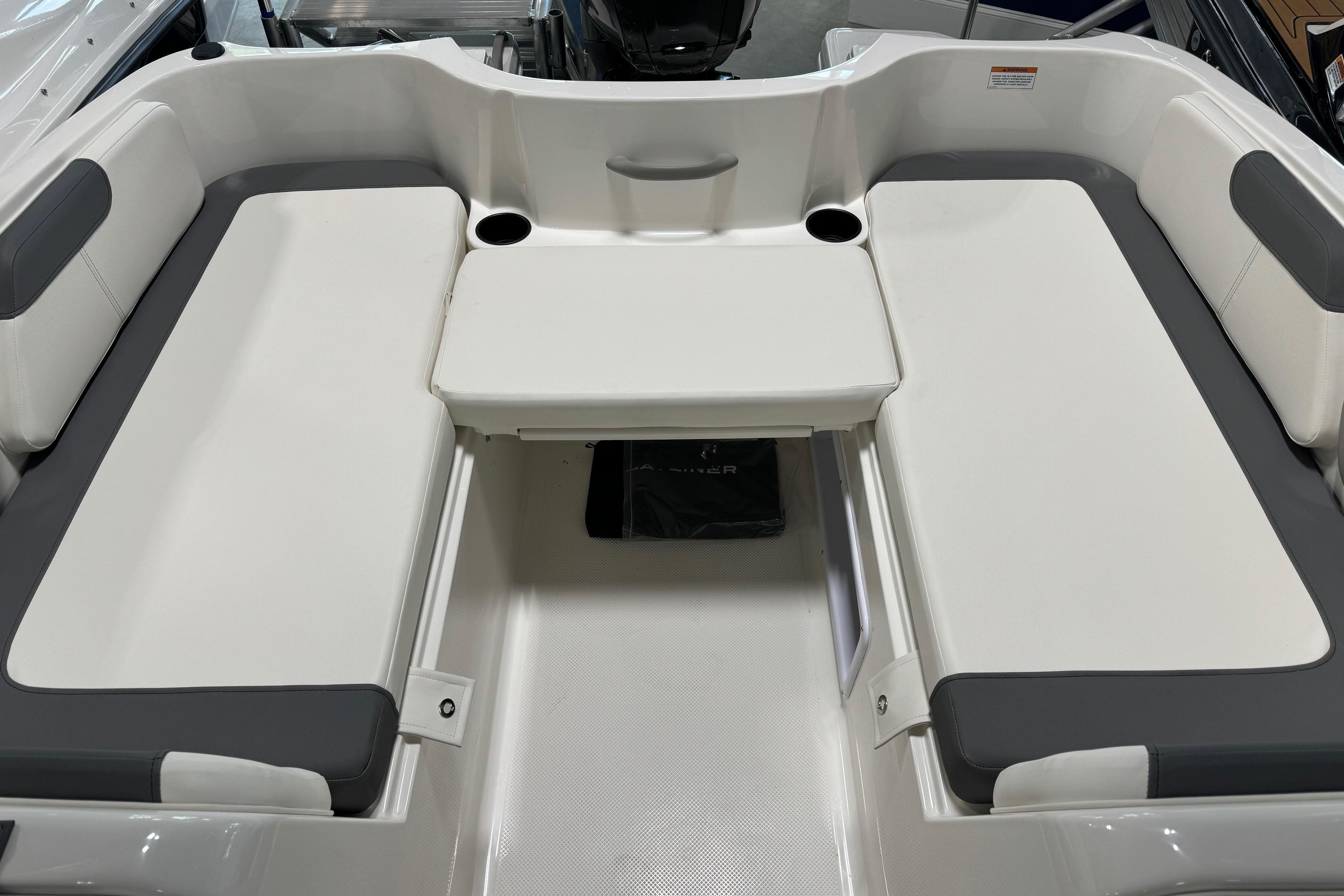 2025 Bayliner Element E18 boat interior with white and gray seating and cup holders.