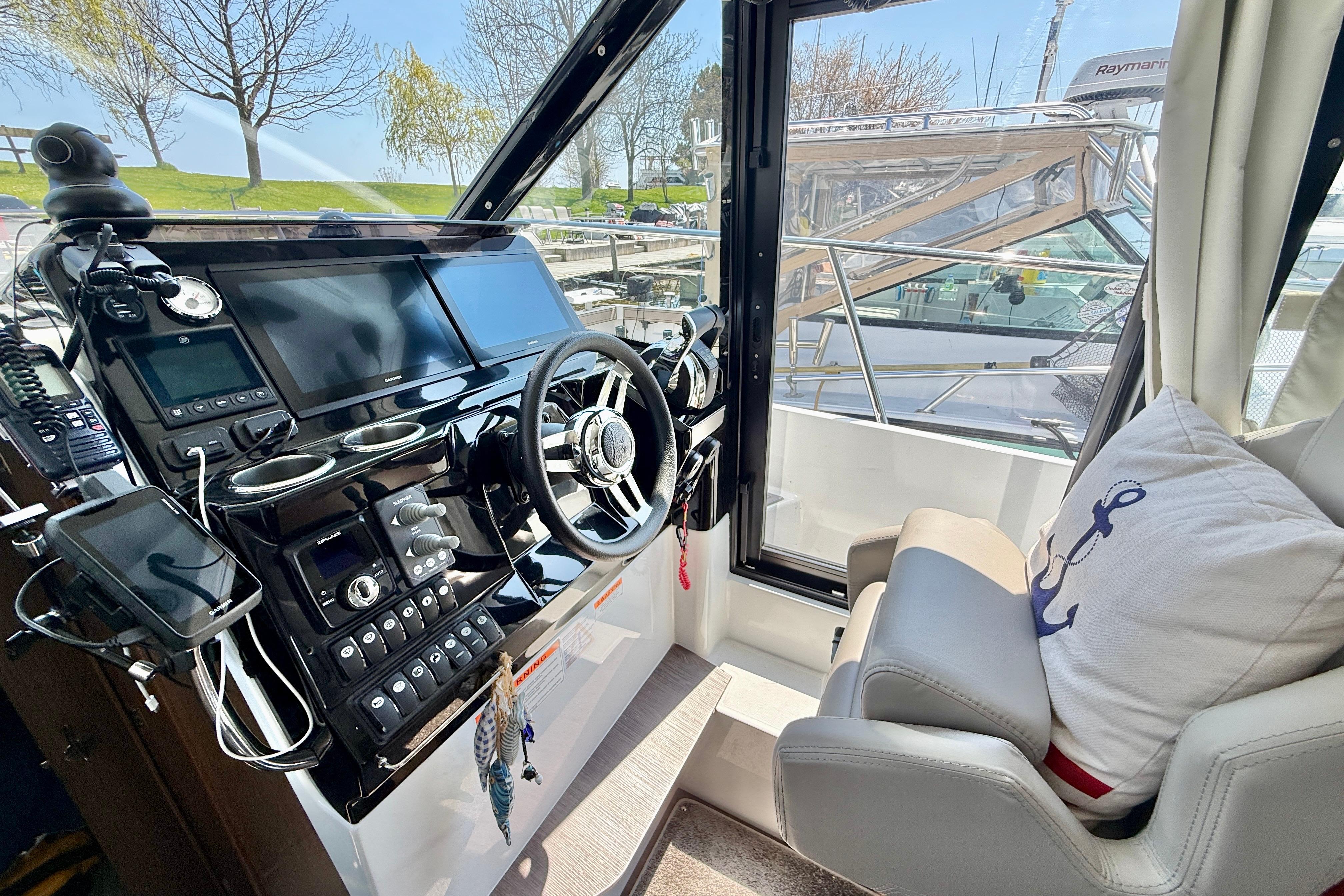 Interior helm of 2022 Jeanneau NC 1095 Fly with modern controls and comfortable seating.