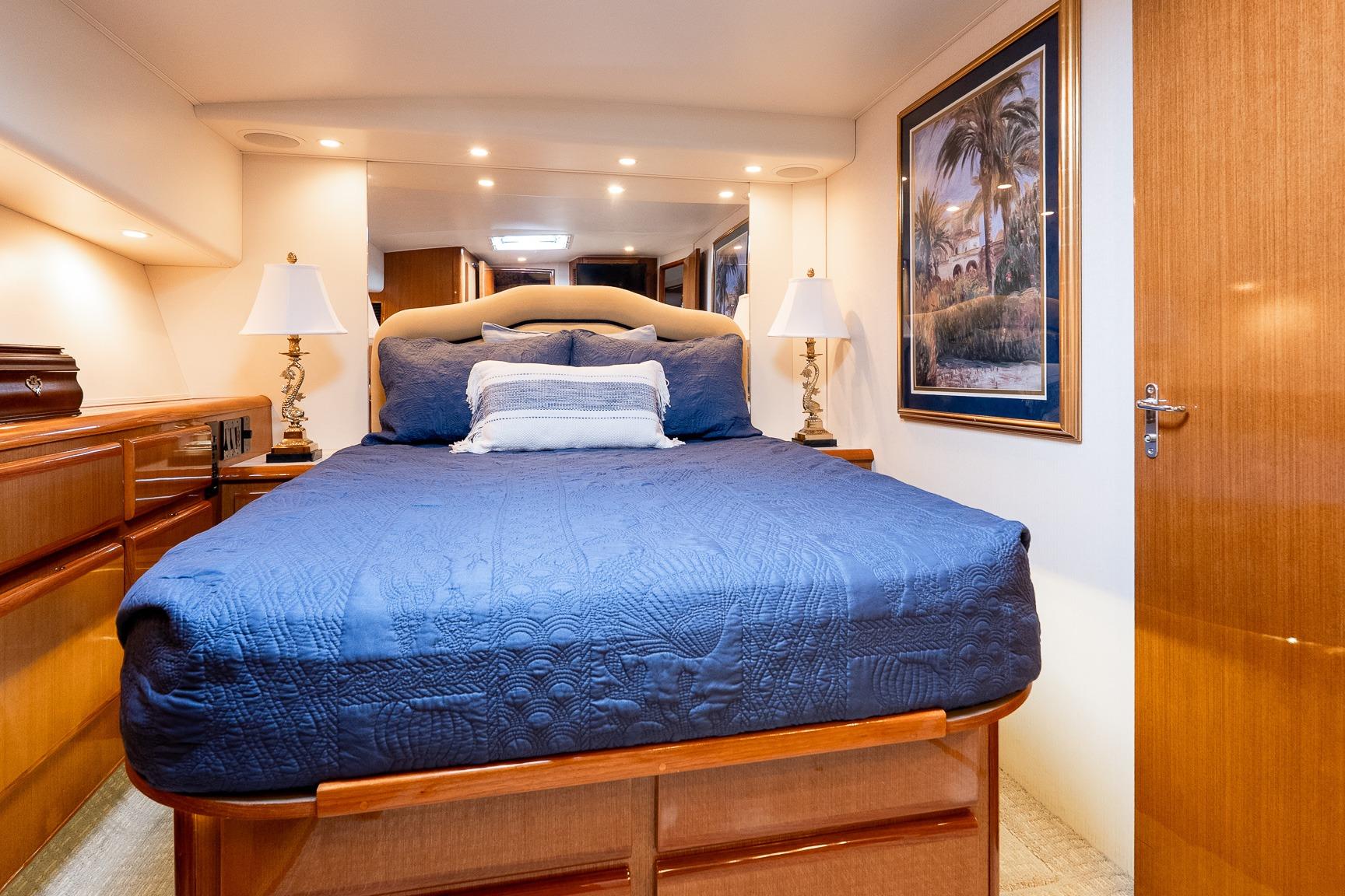 Luxurious bedroom interior of a 2000 Viking 50' Convertible yacht with elegant decor.