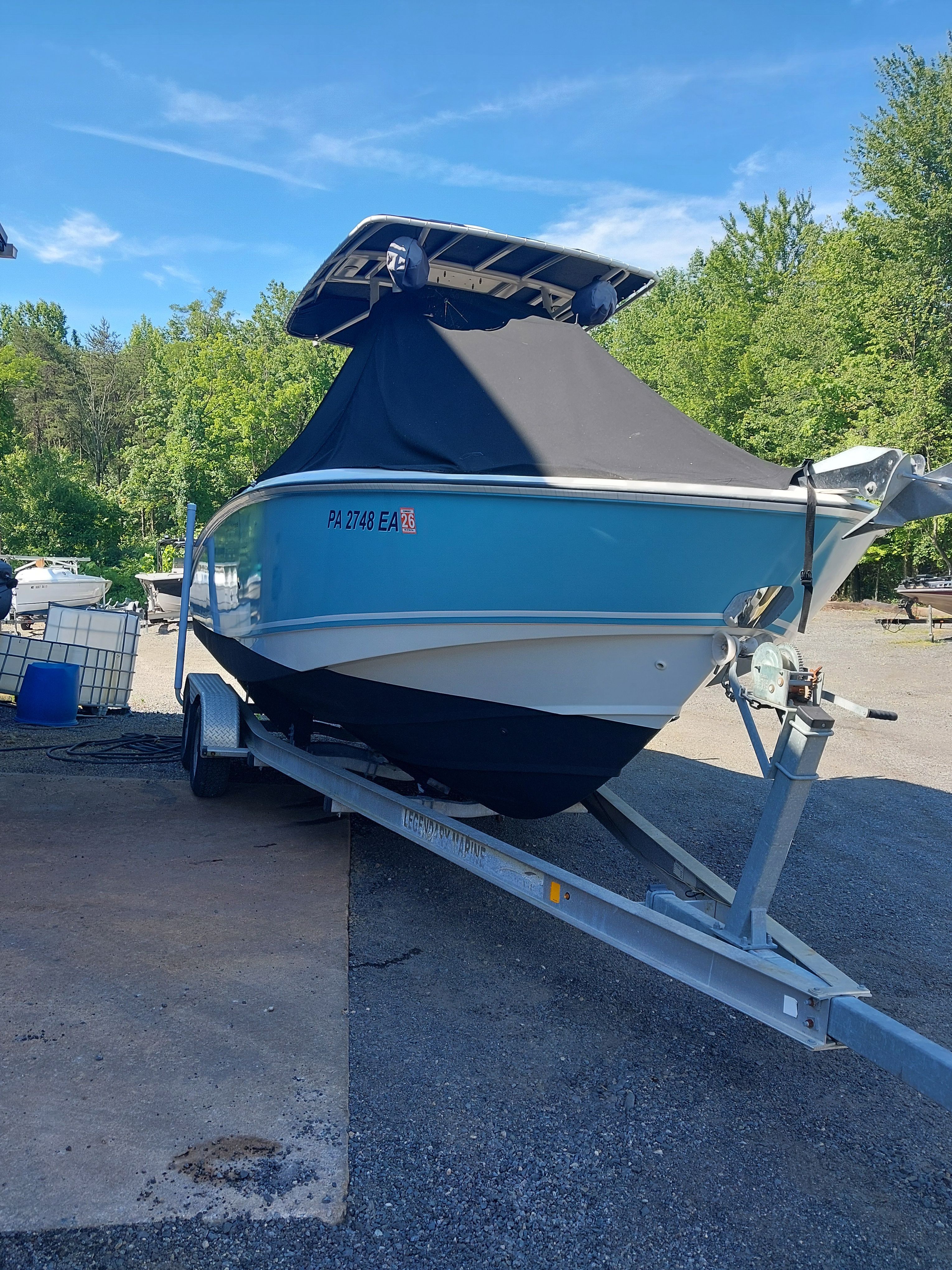 A 2005 Boston Whaler 240 Outrage on a trailer, covered with a protective cover.