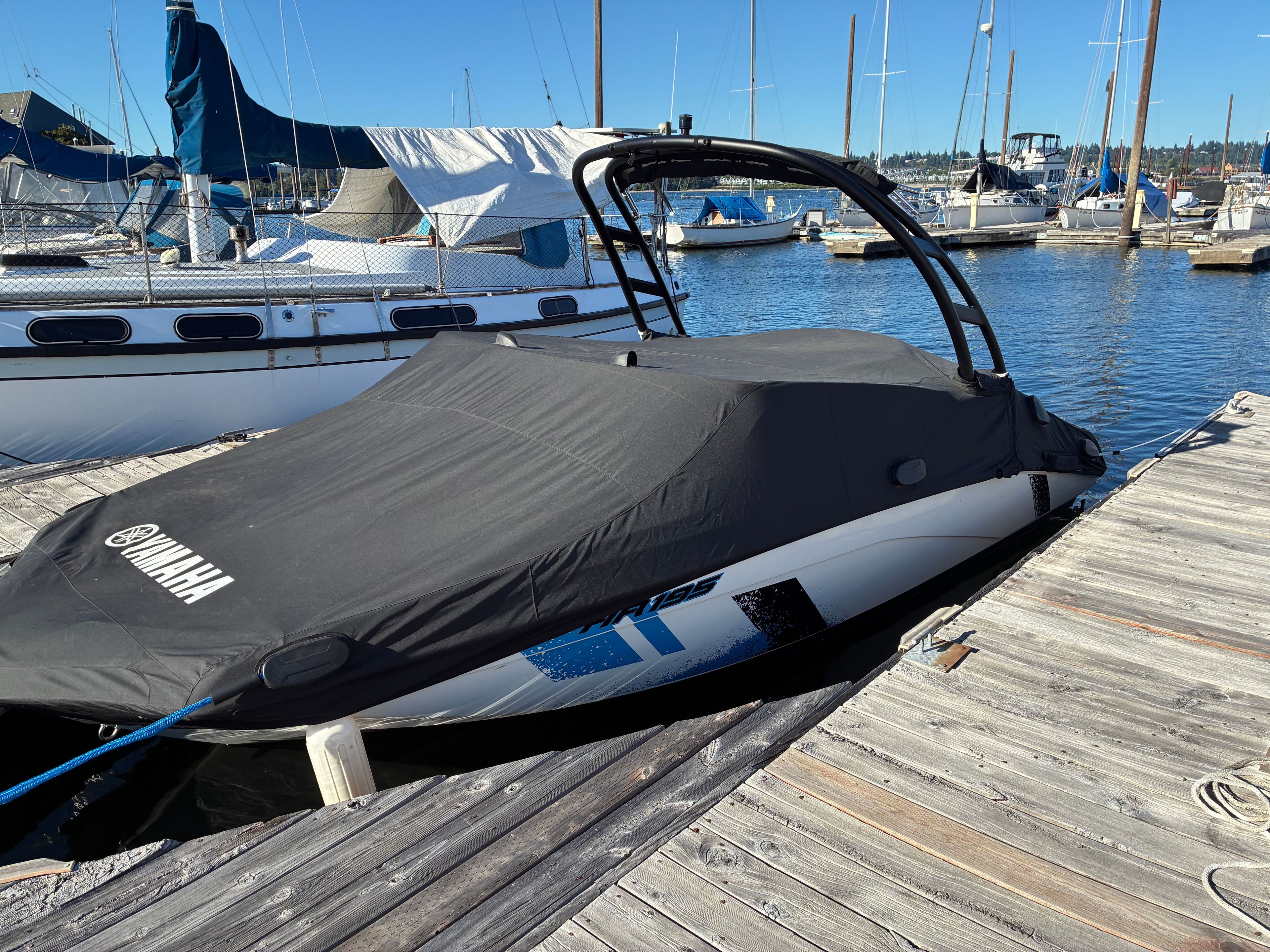 A 2022 Yamaha AR195 boat is docked with a cover on.