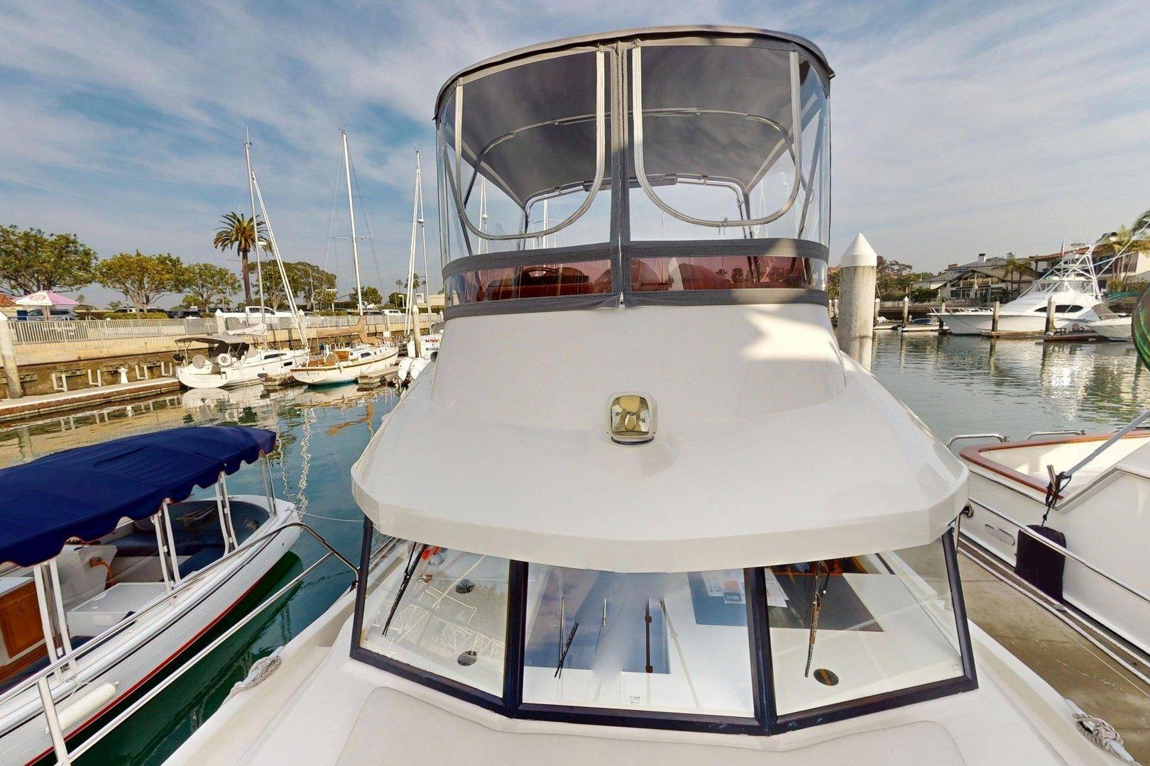 2021 Beneteau Swift Trawler 35 docked in a marina, surrounded by other boats.